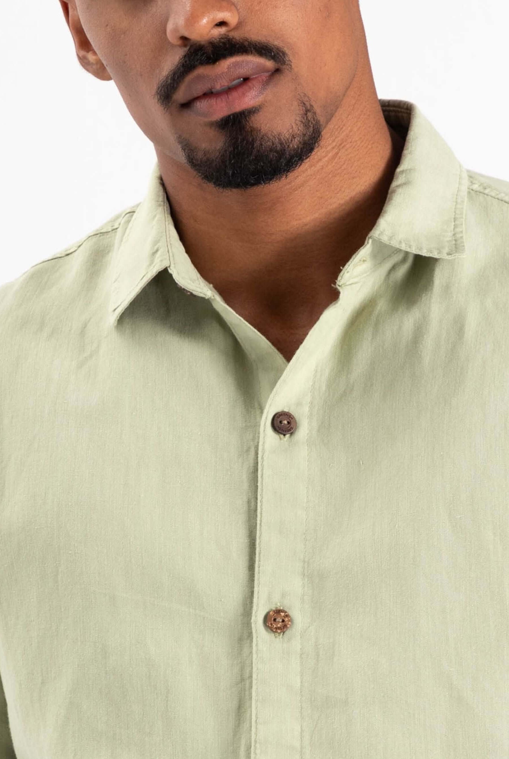 Camisa botão hemp canhamo verde da marca Greenish, com botão marrom e tecido leve, ideal para o verão.