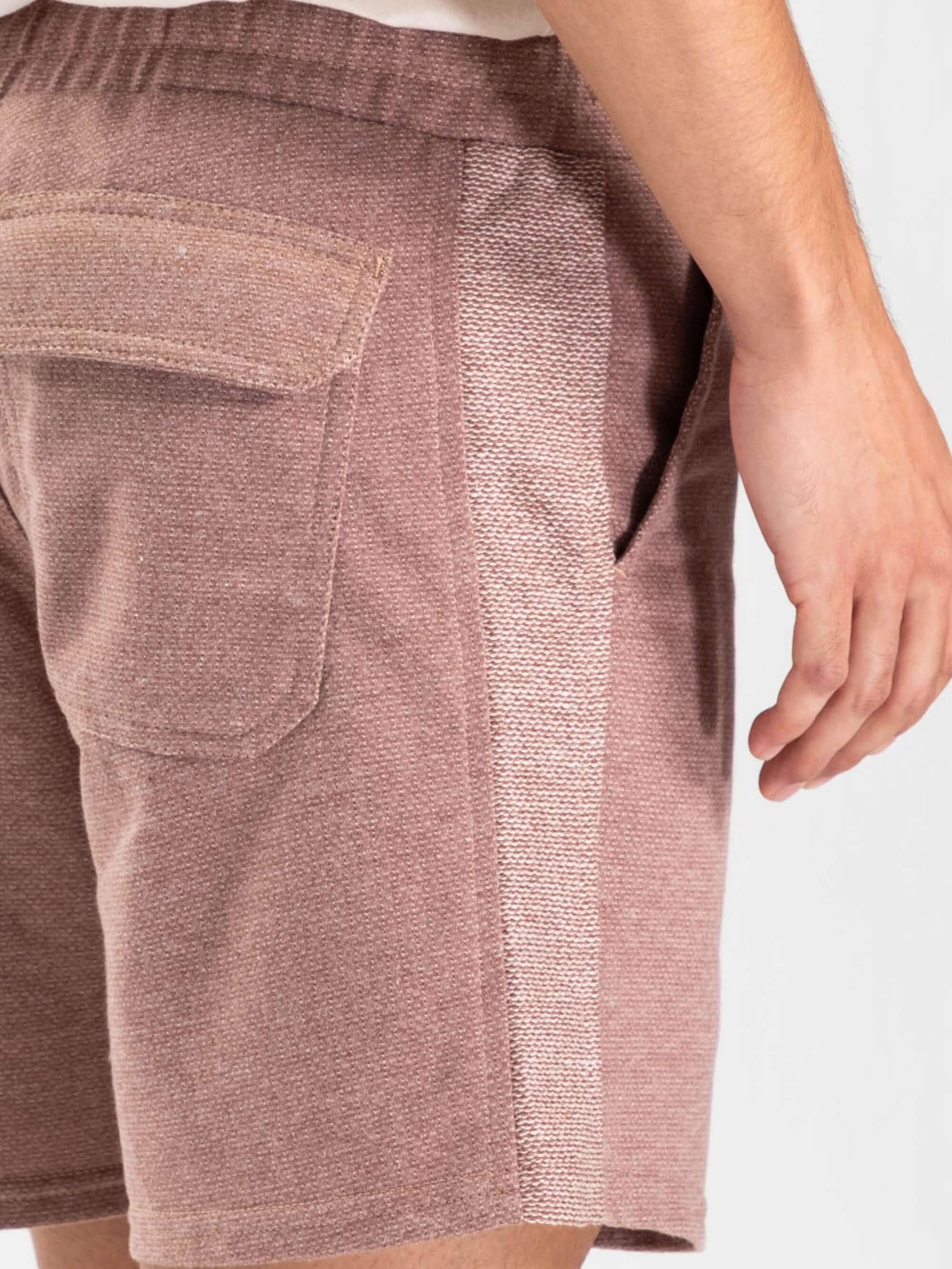 Vista lateral do Short Moletom Rustic bege da Greenish, mostrando detalhes do bolso e do cós elástico.