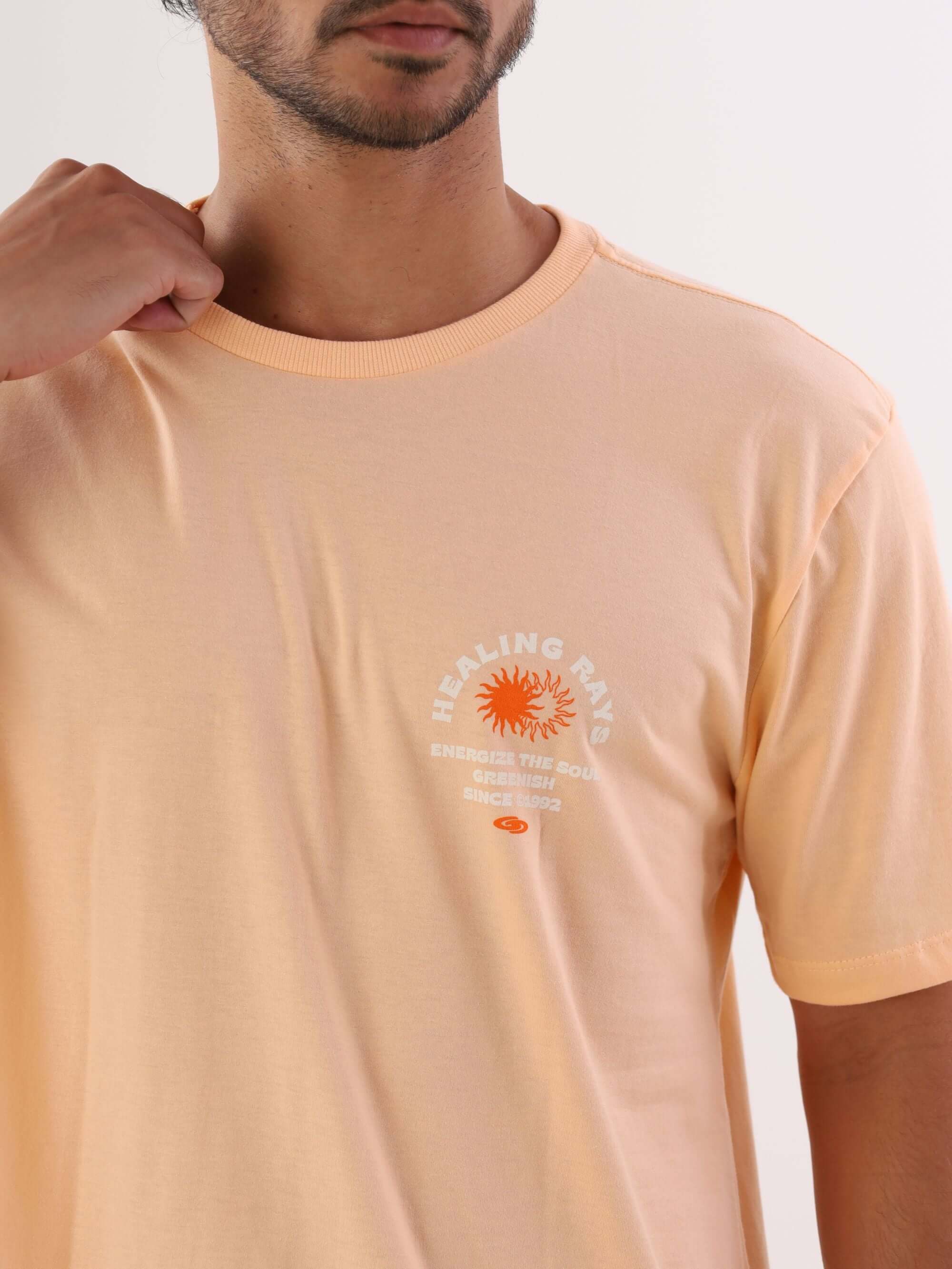 Camiseta Healing Rays cor salmão da marca Greenish, destacando estampa do sol e design moderno.