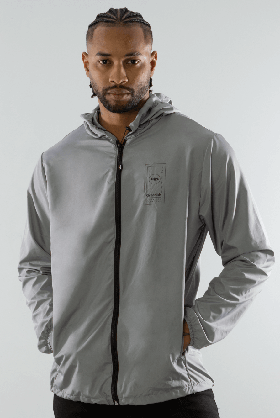 Casaco Corta Vento Dreamms da Greenish, leve e portátil, ideal para dias de vento, com capuz e bolsos laterais.