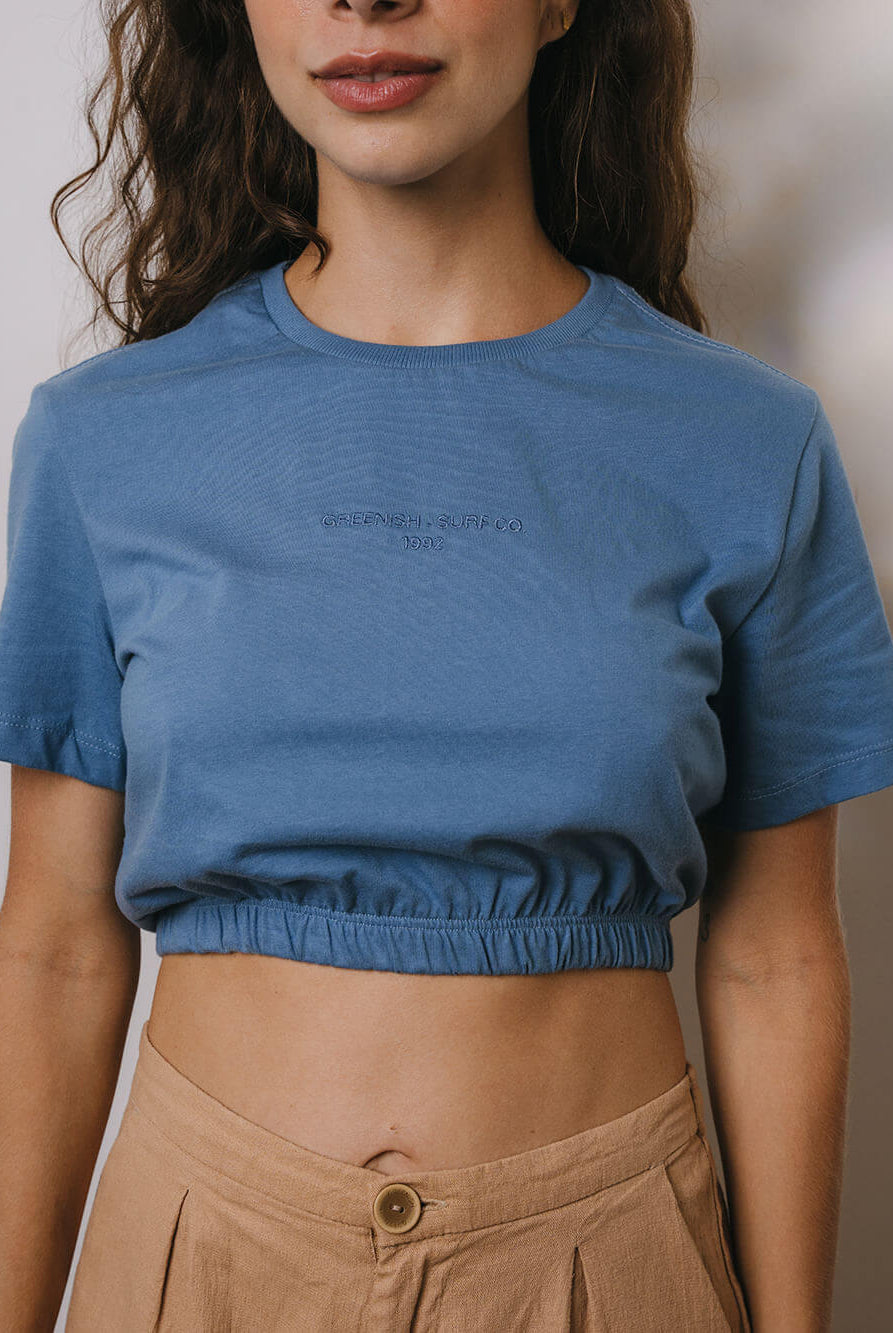 Blusa cropped azul médio da marca Greenish, perfeita para looks casuais e frescos, destacando elegância e conforto.