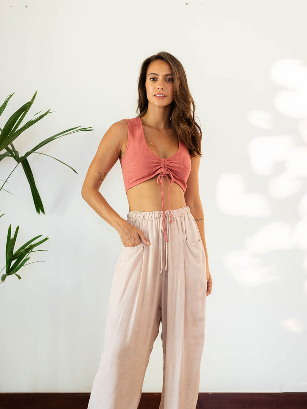 Top Andy Coral da marca Greenish, vestindo look casual e confortável com textura canelada e decote em V.