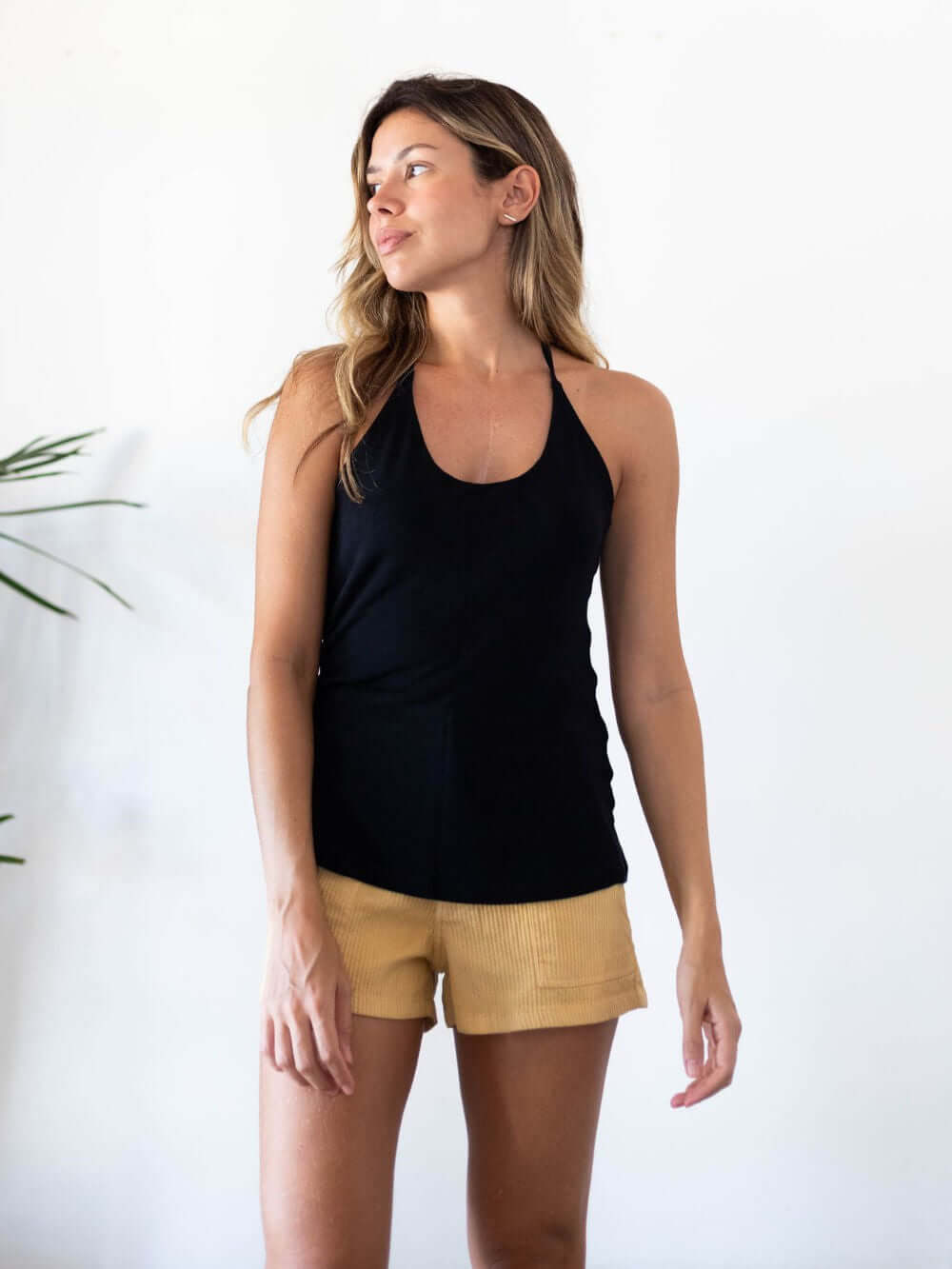 Mulher usando blusa Micca preta, com amarração no pescoço, estilo leve e ideal para o verão. Greenish.