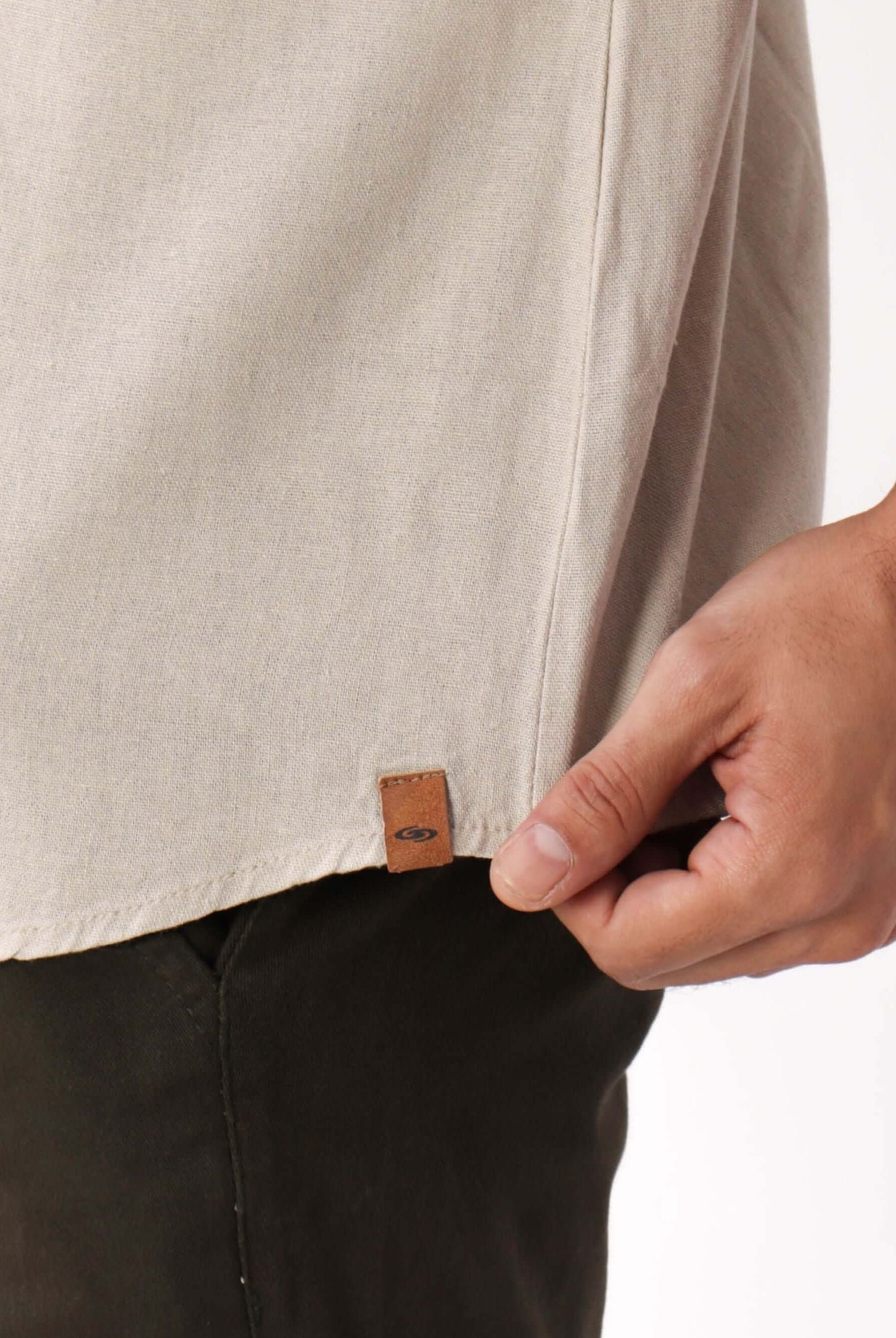 Camisa Botão Nature da Greenish em bege, com detalhe da etiqueta de couro, perfeita para sobreposições elegantes.
