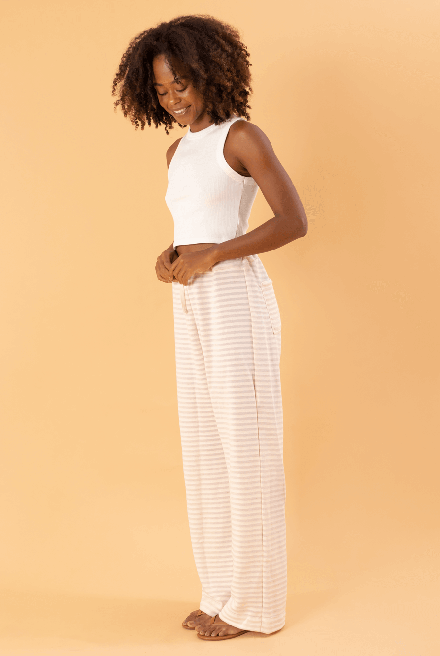 Modelo usando calça So Easy bege da marca Greenish, destacando seu estilo moderno e confortável.