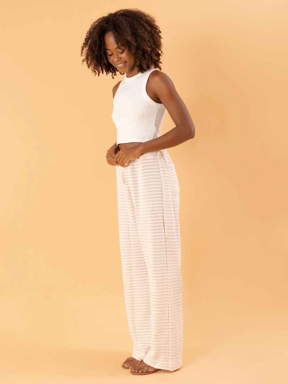 Modelo usando calça So Easy bege da marca Greenish, destacando seu estilo moderno e confortável.