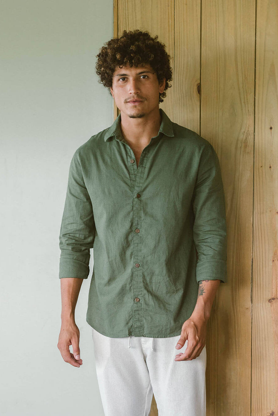 Homem usando camisa longa de linho verde da Greenish, combinando estilo casual e formal.