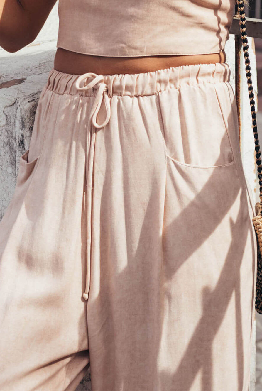 Calça Cecília Bege da Greenish com cós elástico, bolsos e corte reto, ideal para dias quentes e conforto absoluto.