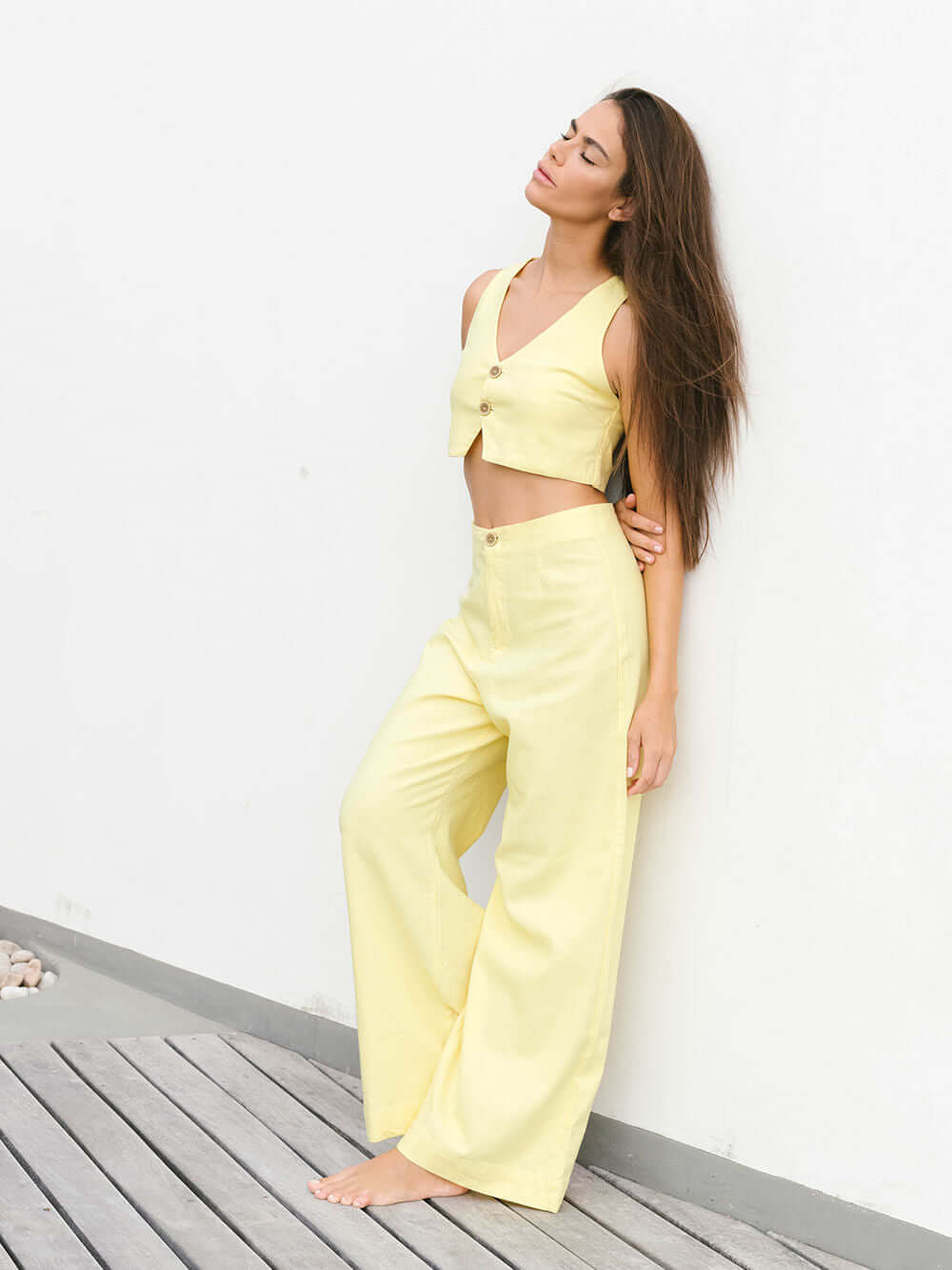 Modelo usando calça Hazel amarela da Greenish, com caimento pantalona e estilo vintage.