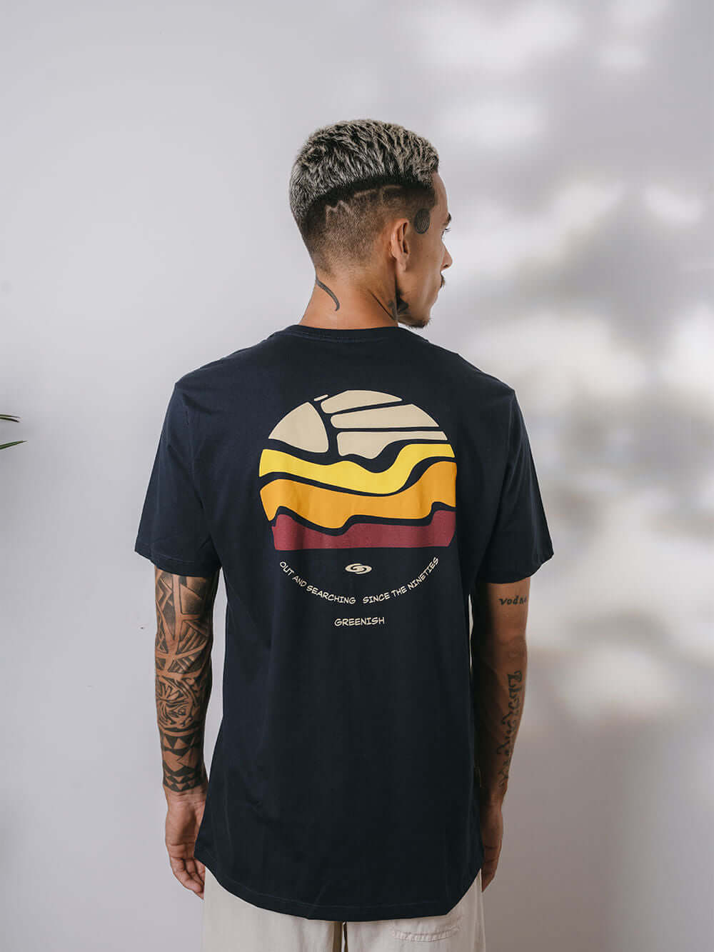 Camiseta Summer Trip da Greenish, estampa colorida sobre fundo azul escuro, modelo clássico e confortável.