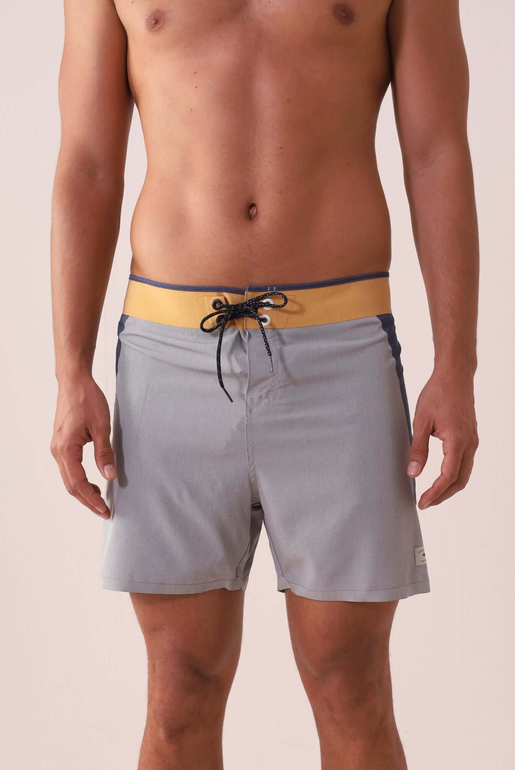 Homem vestindo Boardshort Ultralight II Sunset - Cinza da marca Greenish, destacando design multicolorido e tecido de alta performance.