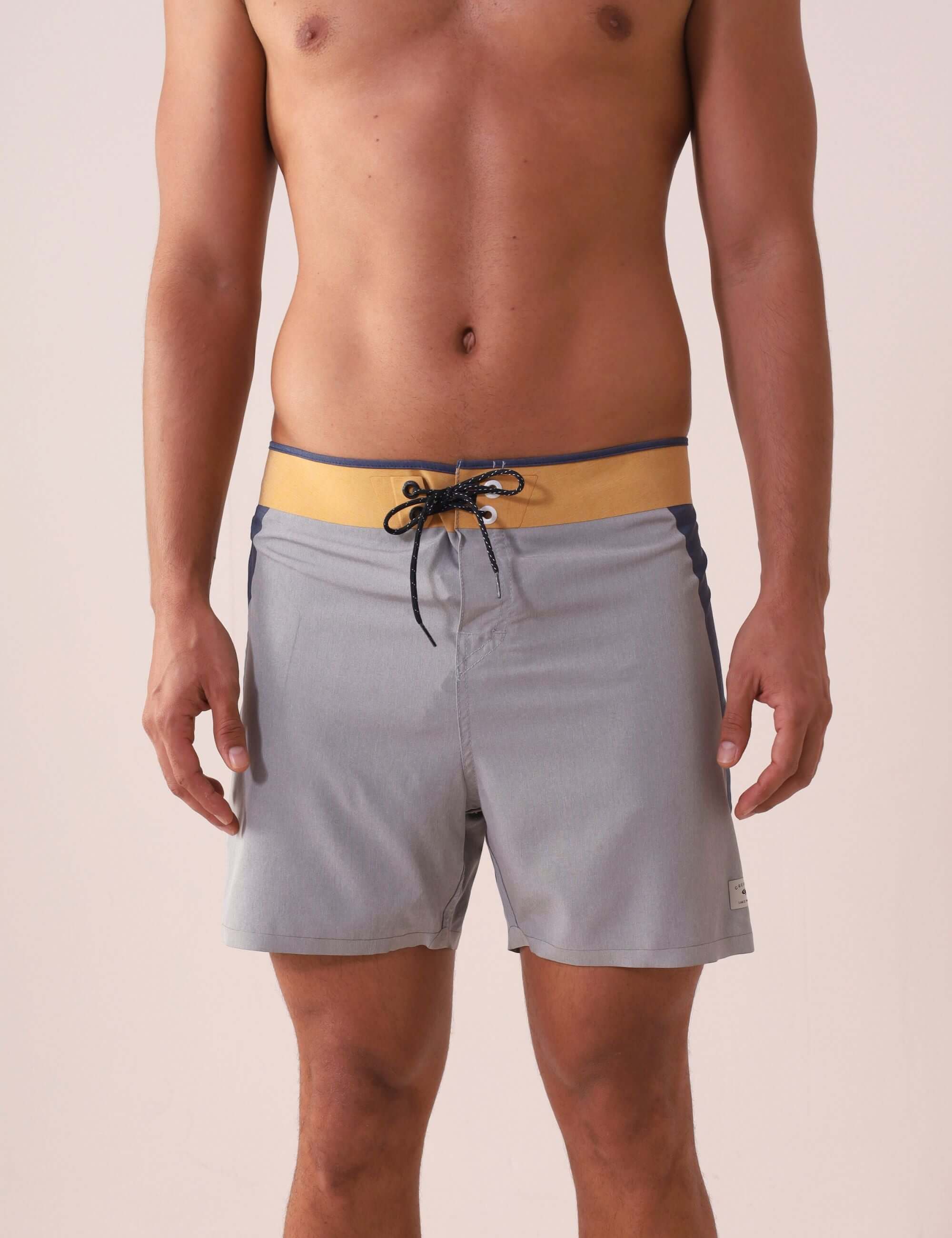 Homem vestindo Boardshort Ultralight II Sunset - Cinza da marca Greenish, destacando design multicolorido e tecido de alta performance.