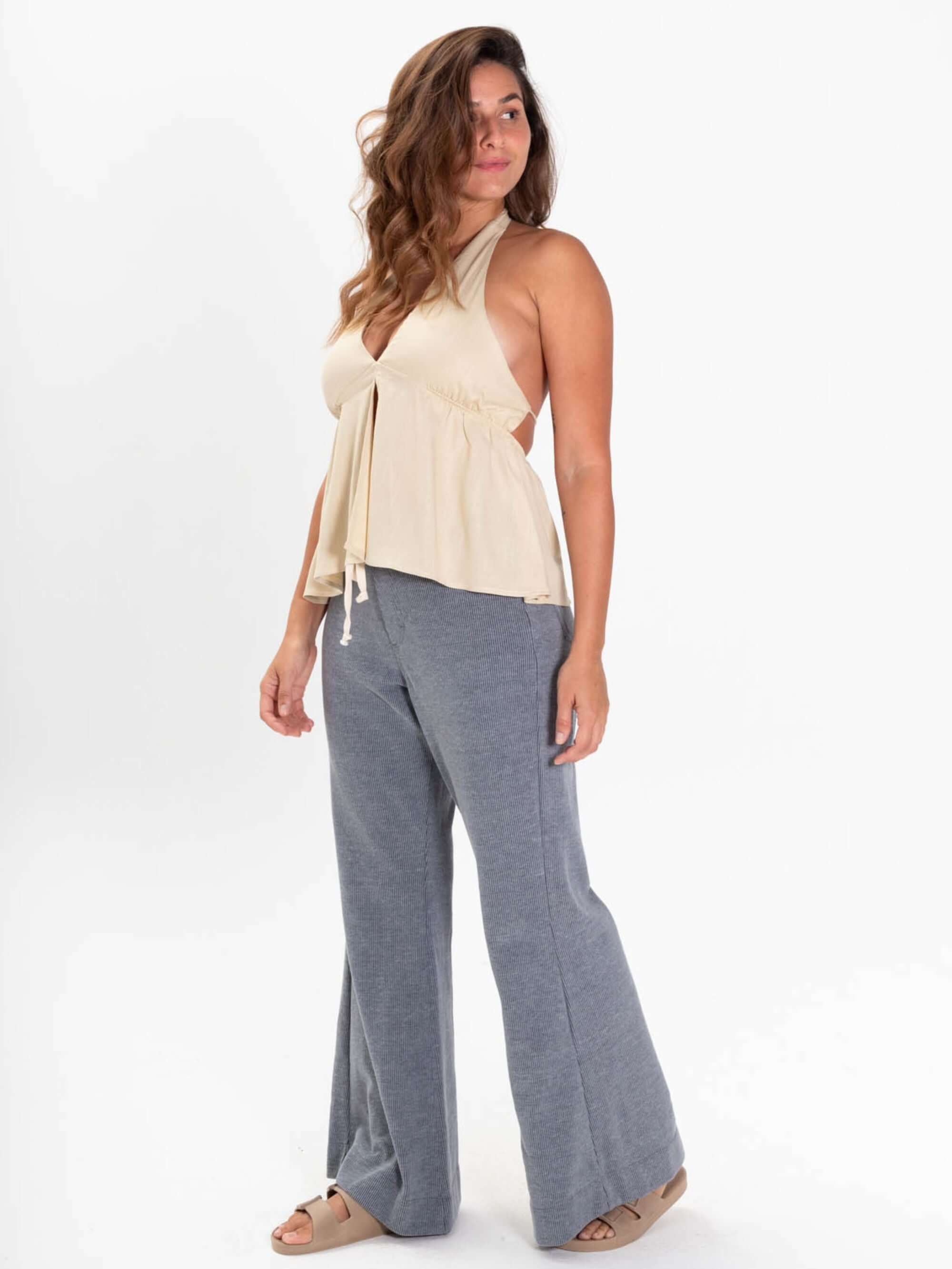 Mulher usando blusa Breezy da Greenish, confortável, com decote em V e amarrações, perfeita para o verão.