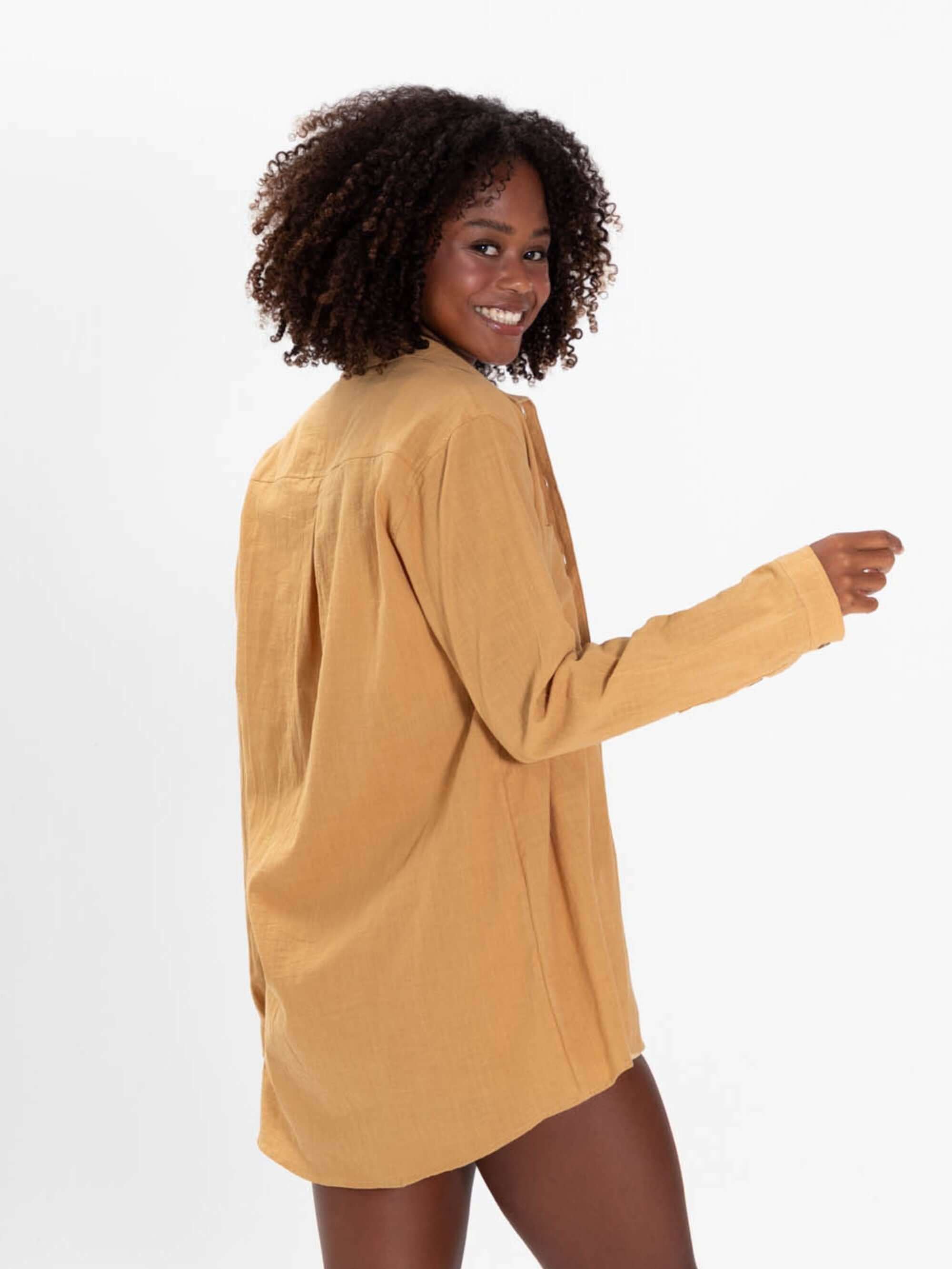 Modelo feminina usando a Camisa Jennie beige da Greenish, com mangas longas e caimento soltinho.