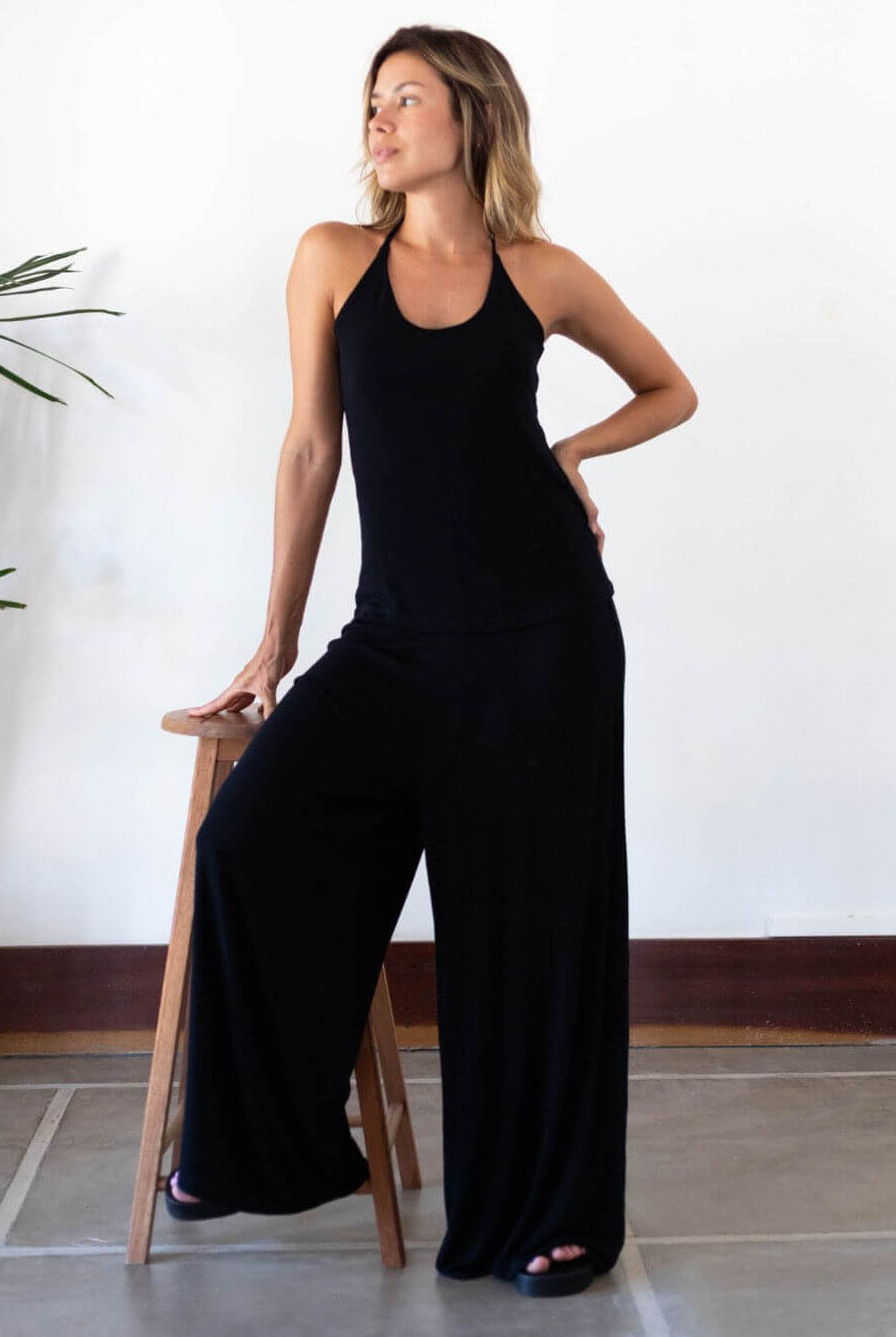 Mulher usando calça Micca preta da Greenish, destacando conforto e estilo moderno.