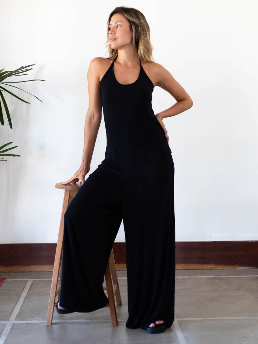 Mulher usando calça Micca preta da Greenish, destacando conforto e estilo moderno.