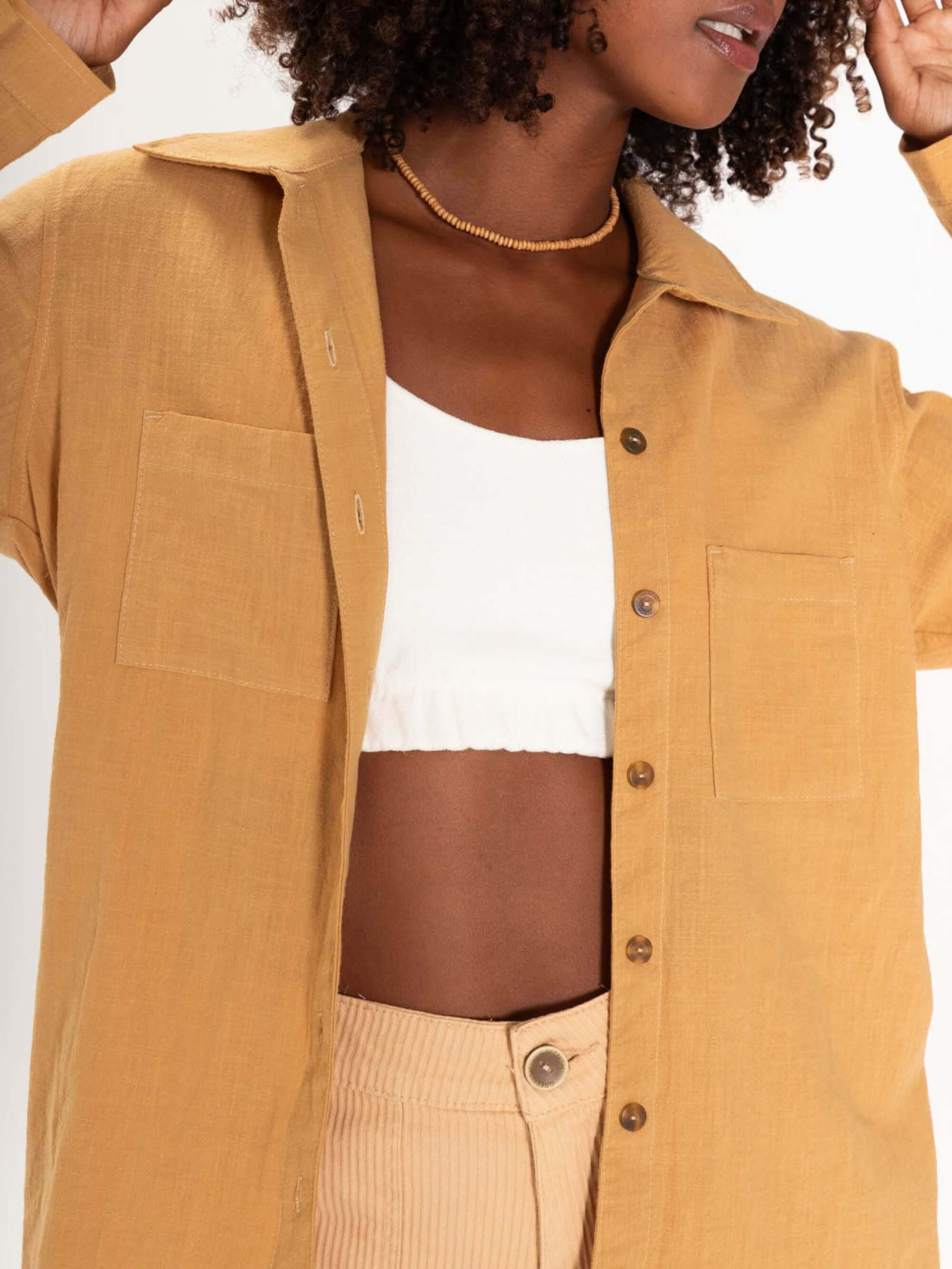 Camisa Jennie bege da Greenish, com mangas longas, bolsos frontais e estilo versátil para looks modernos.