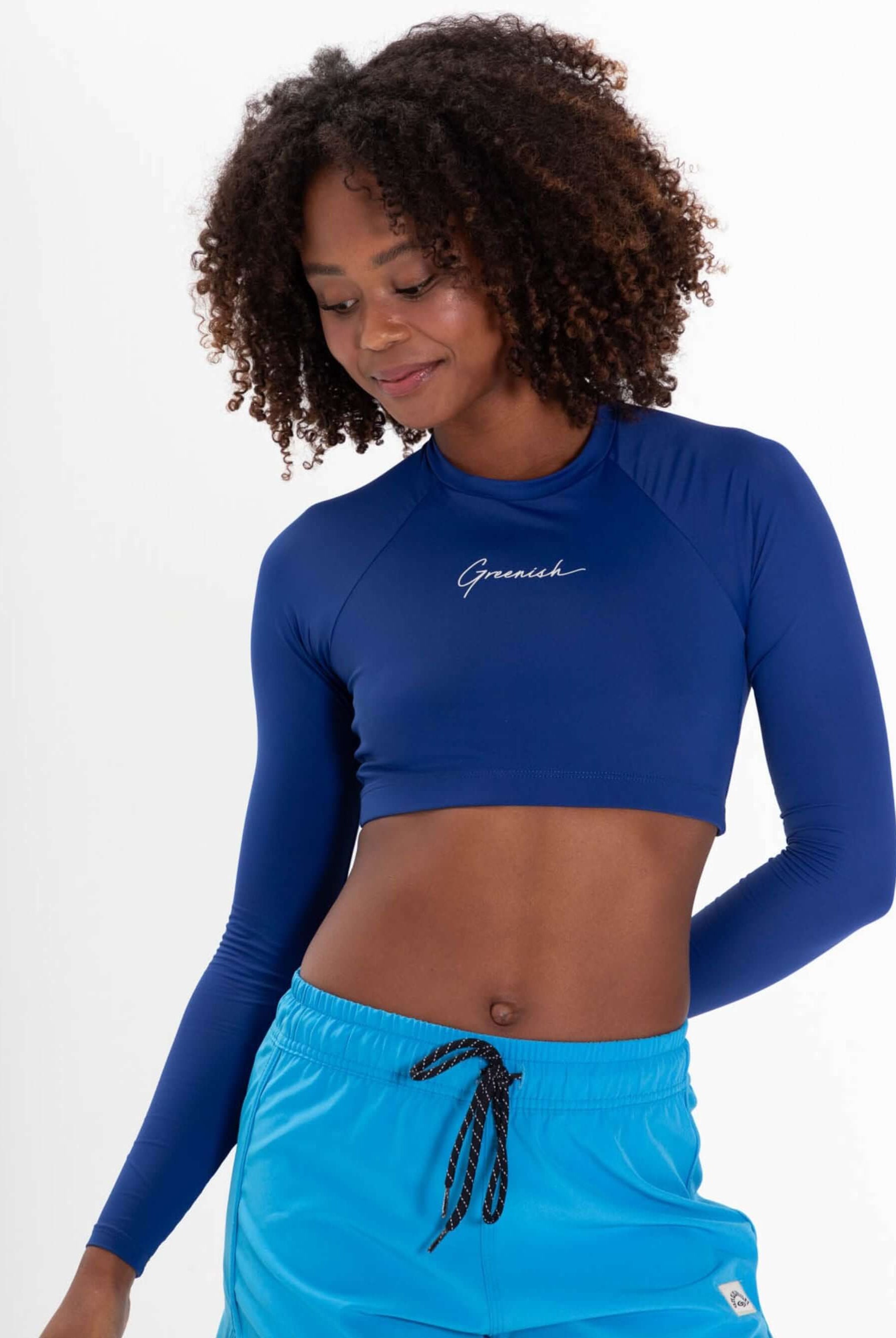 Mujer usando o Colete Cropped Basic da Greenish na cor azul, ideal para praia e atividades aquáticas, com proteção UV.