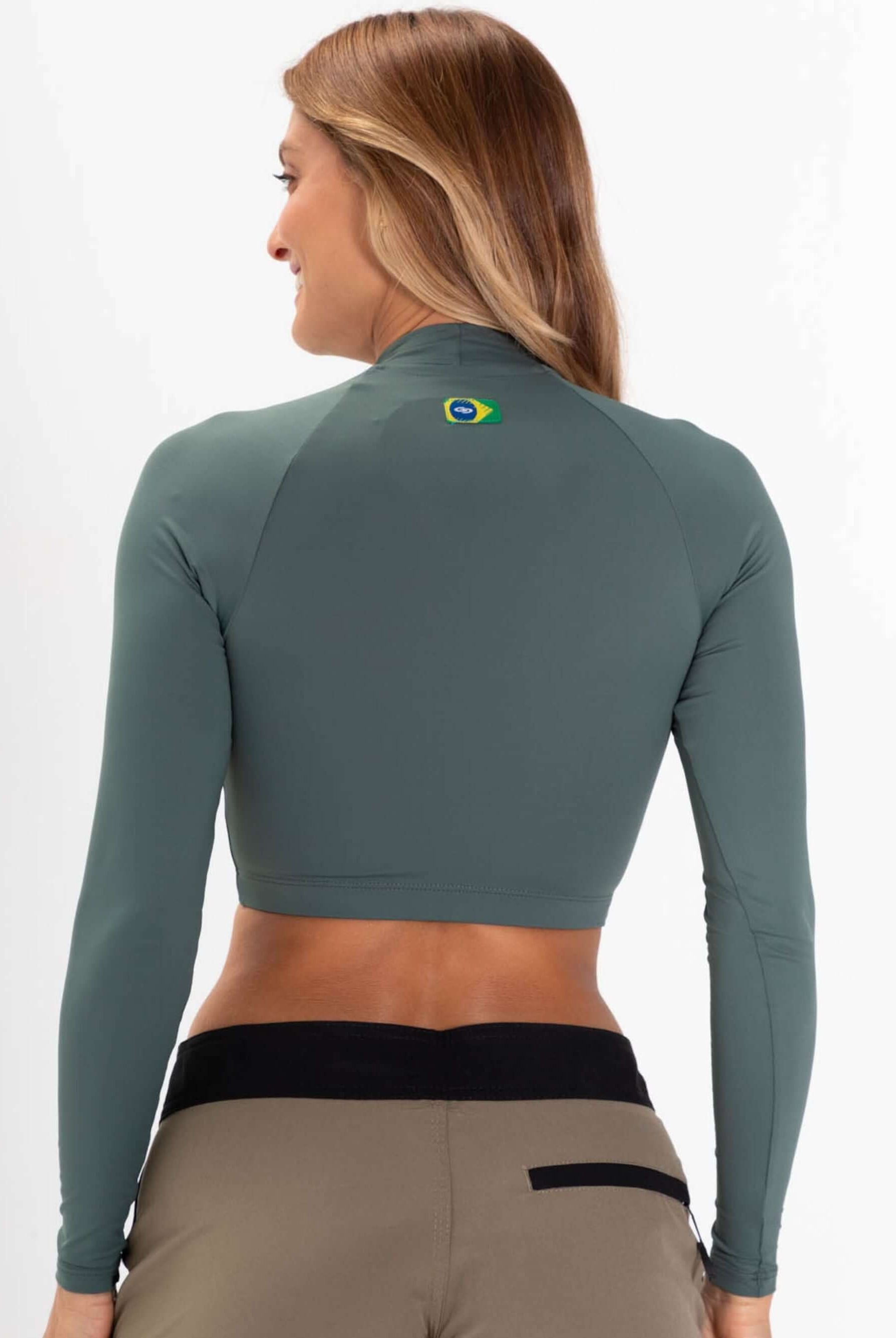 Mulher usando colete cropped verde da Greenish, ideal para surf e atividades ao ar livre, com proteção UV.