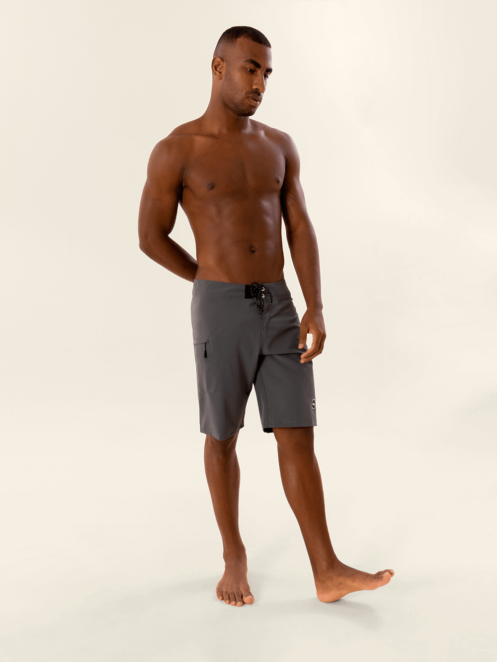 Model wearing Greenish Total Stretch boardshorts in cinza color, showcasing versatility and performance for water sports.