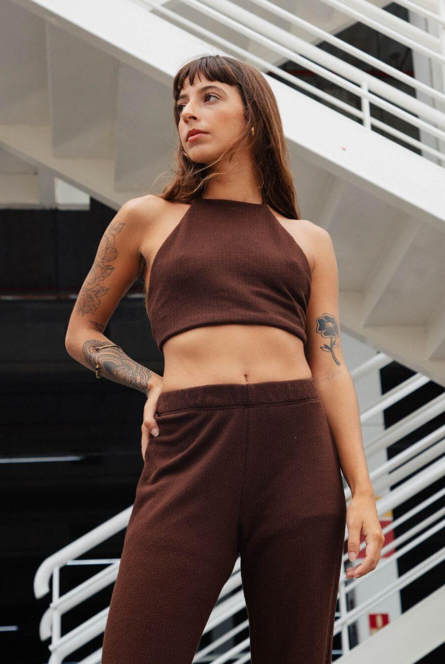 Modelo usando calça tricot Ker chocolate da Greenish, conjunto com top tricot, visual moderno e confortável.