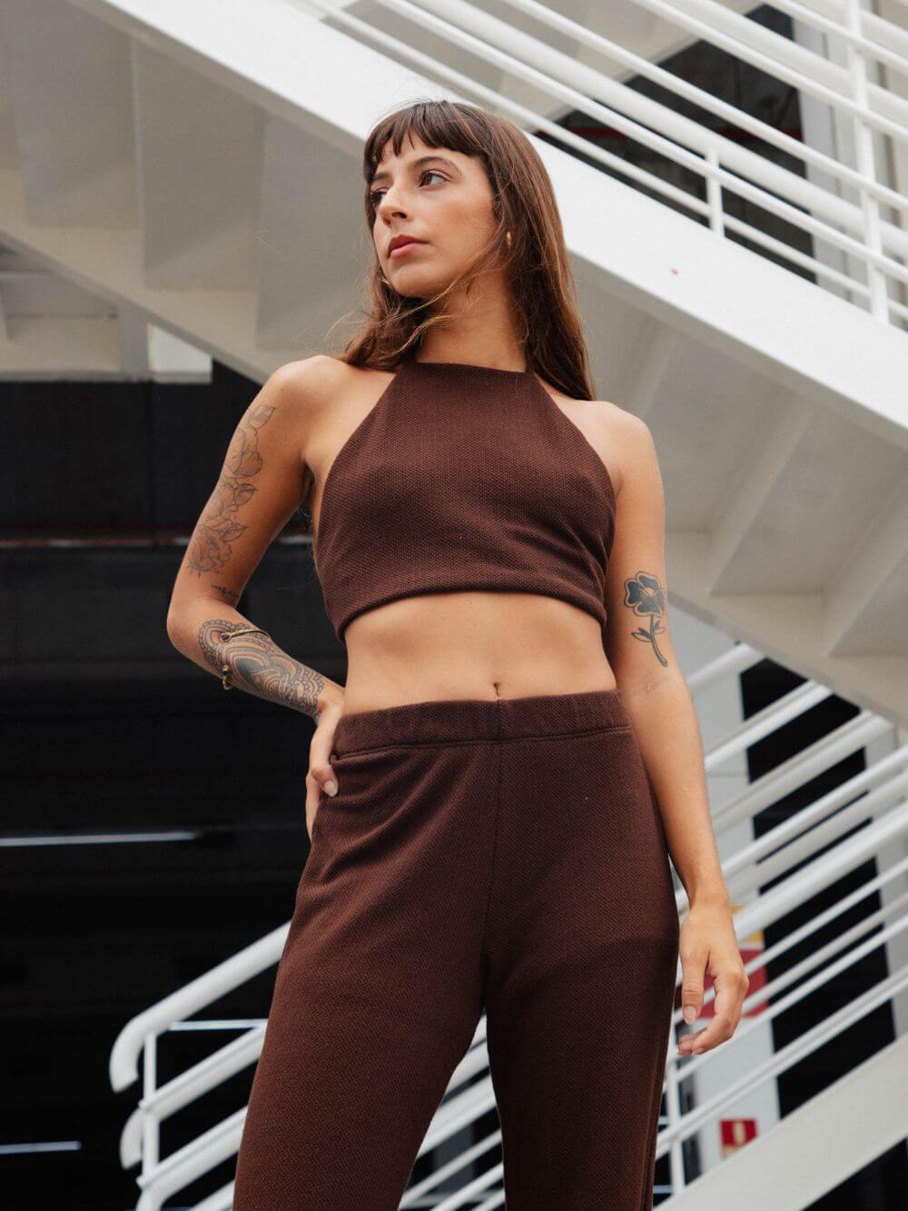 Modelo usando calça tricot Ker chocolate da Greenish, conjunto com top tricot, visual moderno e confortável.