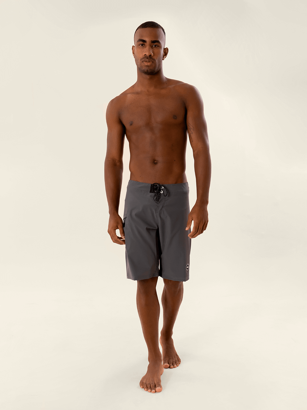 Model wearing Greenish BOARDSHORT TOTAL STRETCH in Cinza color, showcasing comfort and style for water sports.