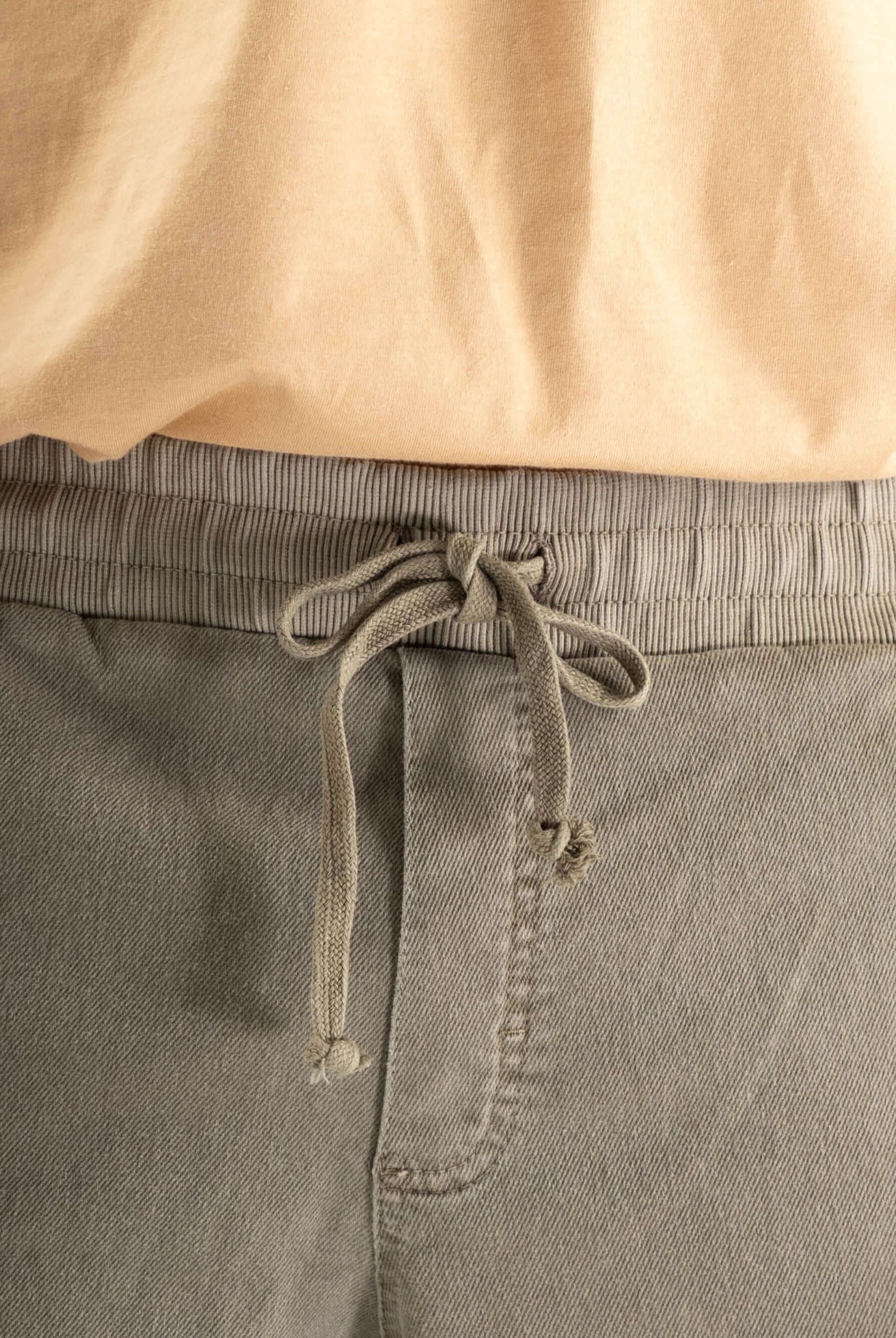 Detalhe do cós elástico e cadarço da calça jogger Greenish, indicando conforto e estilo moderno.