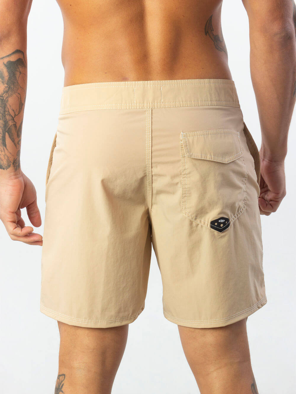 Bermuda bege Greenish, estilo vintage, com caimento acima do joelho e logo diferenciado no bolso traseiro.
