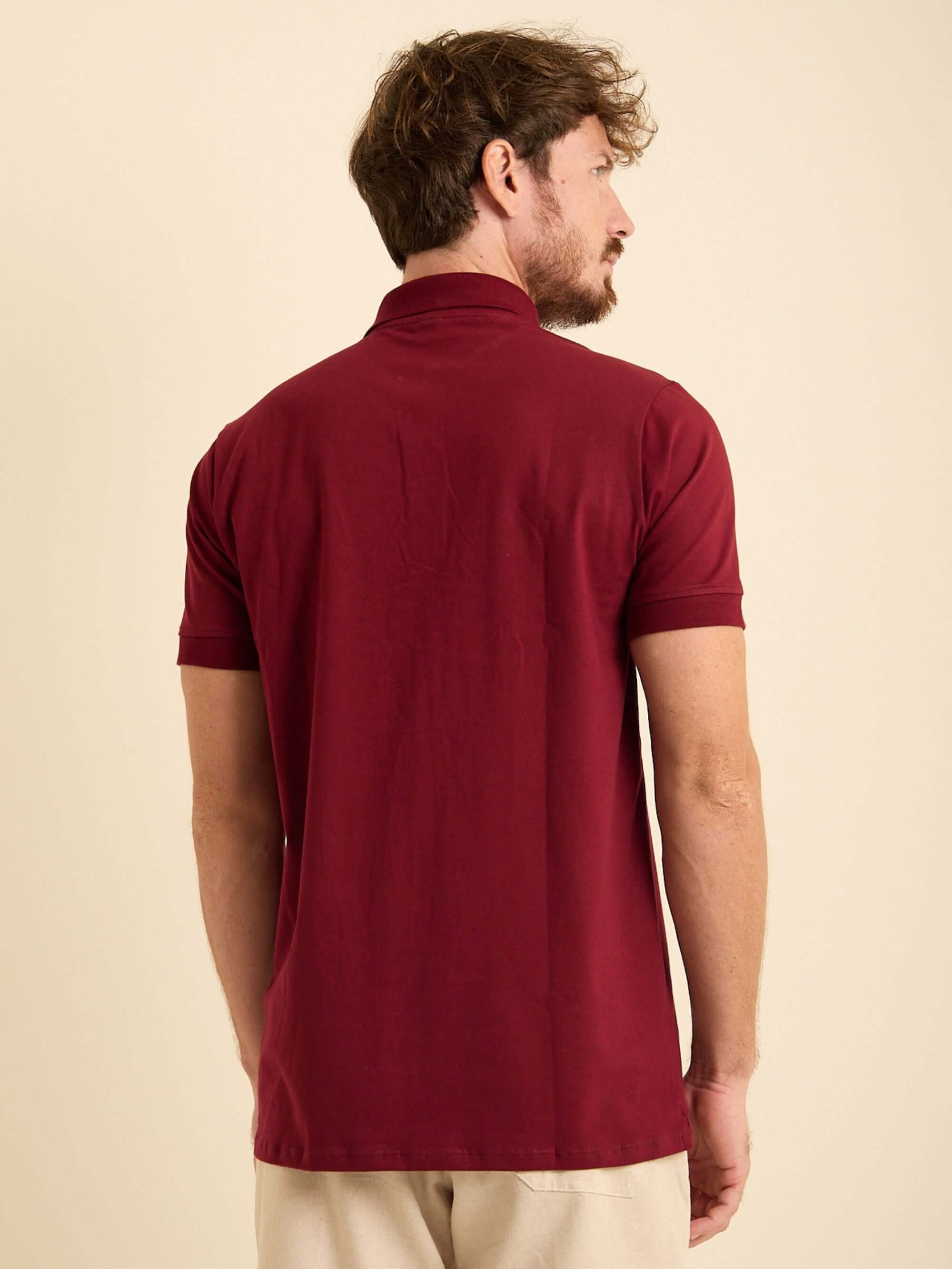 Homem usando camisa polo bordô Greenish vista de costas, ideal para looks casuais em algodão e elastano.
