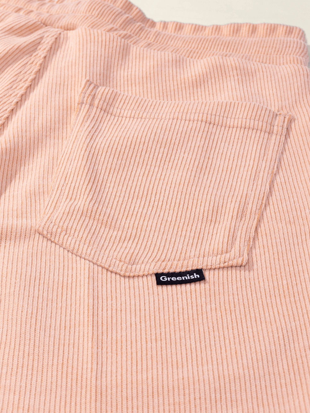 Detalhe do bolso traseiro da Bermuda Tricot Heaven da Greenish, em tecido canelado rosa.