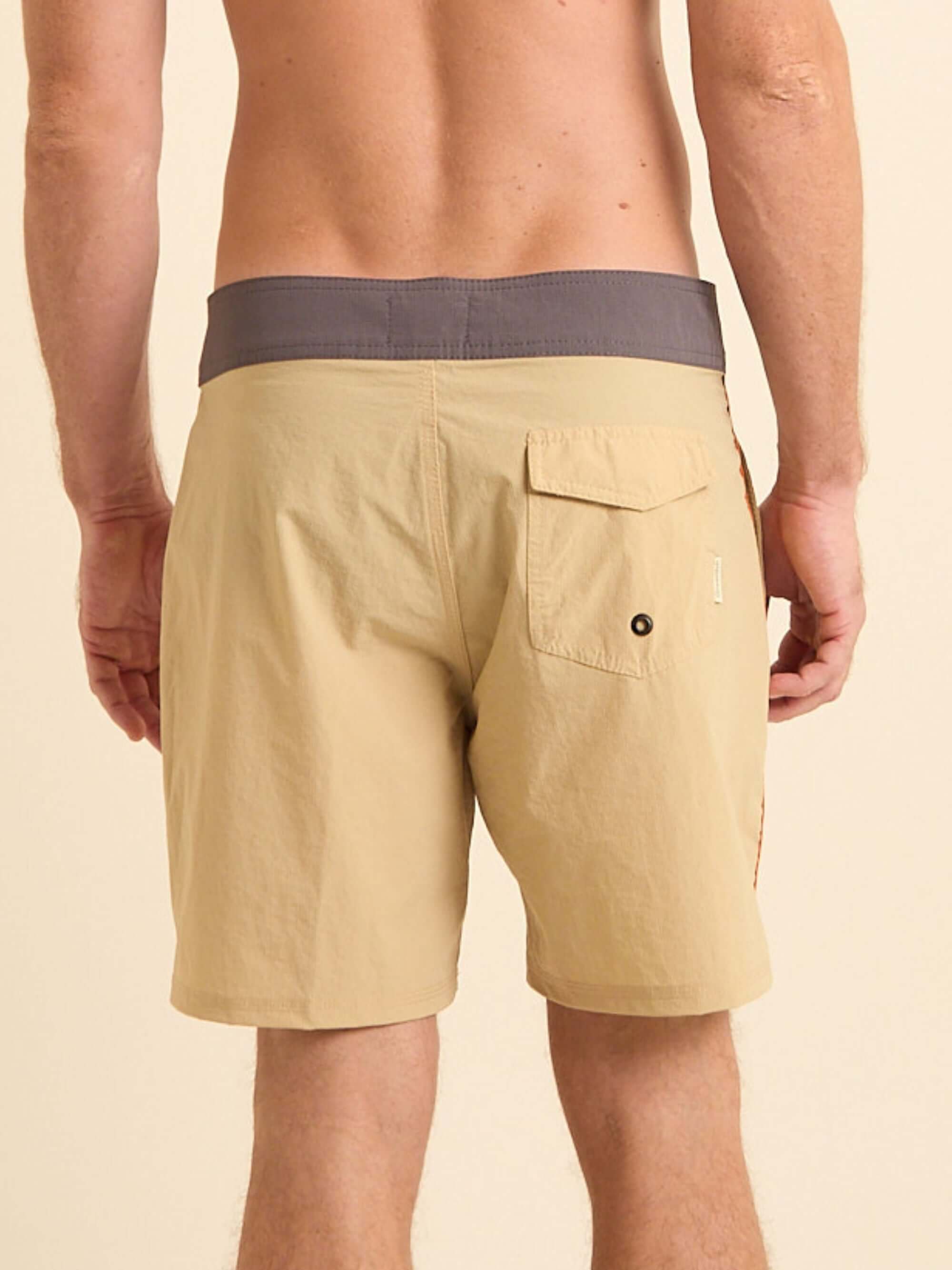 Vista traseira do boardshort bege da Greenish, com cós anatômico e bolso lateral.