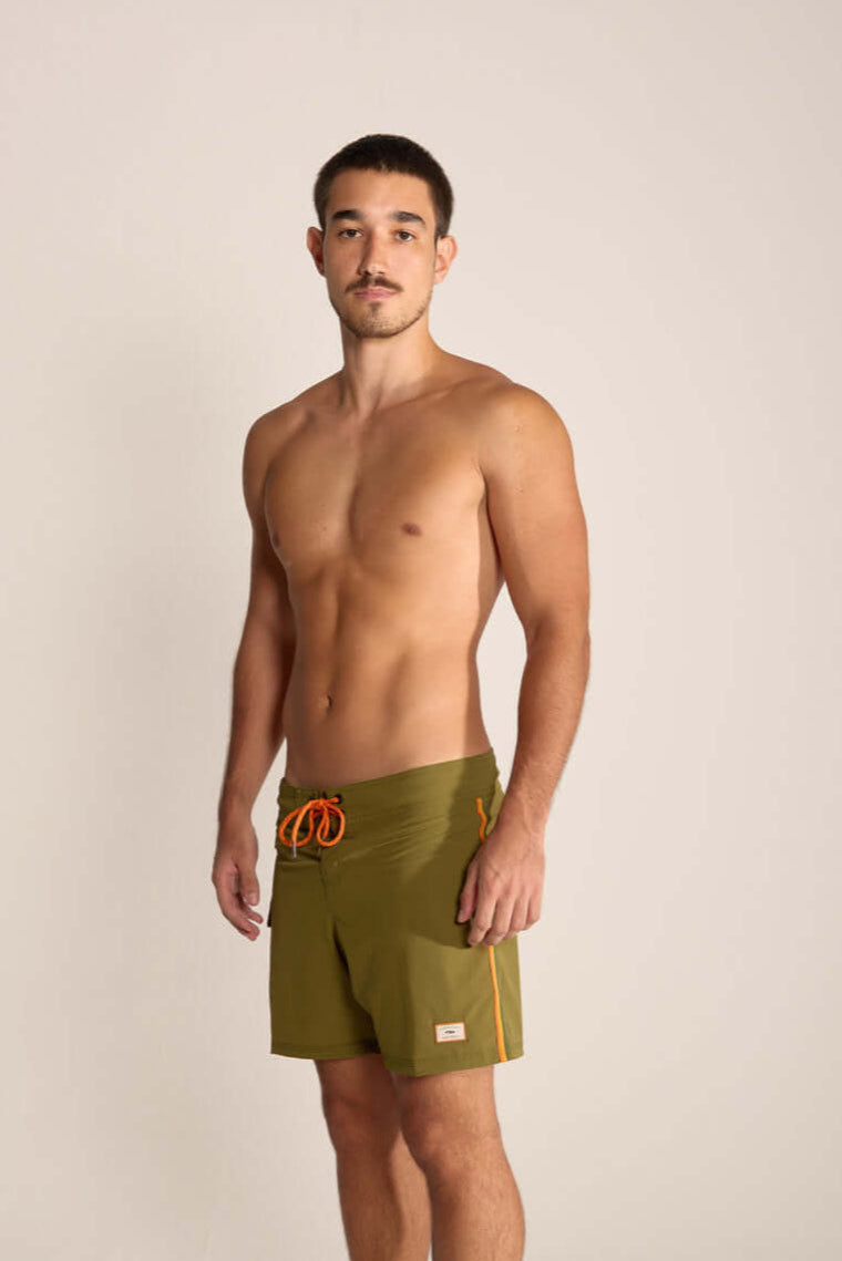 Modelo masculino usando o Boardshort Into the Forest Verde da Greenish, leve e funcional para atividades ao ar livre.
