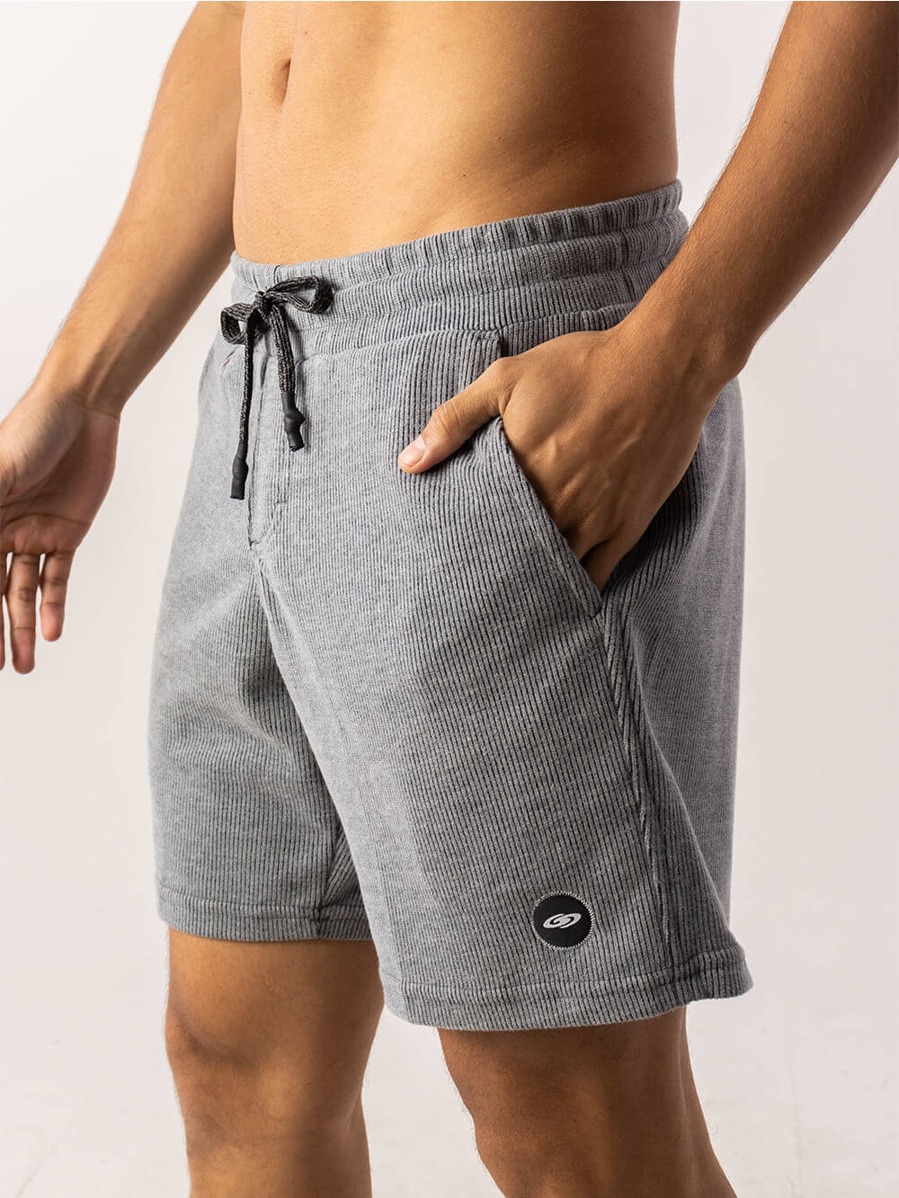 Bermuda tricot masculina em tecido canelado, com bolsos e etiqueta Greenish, na cor cinza.