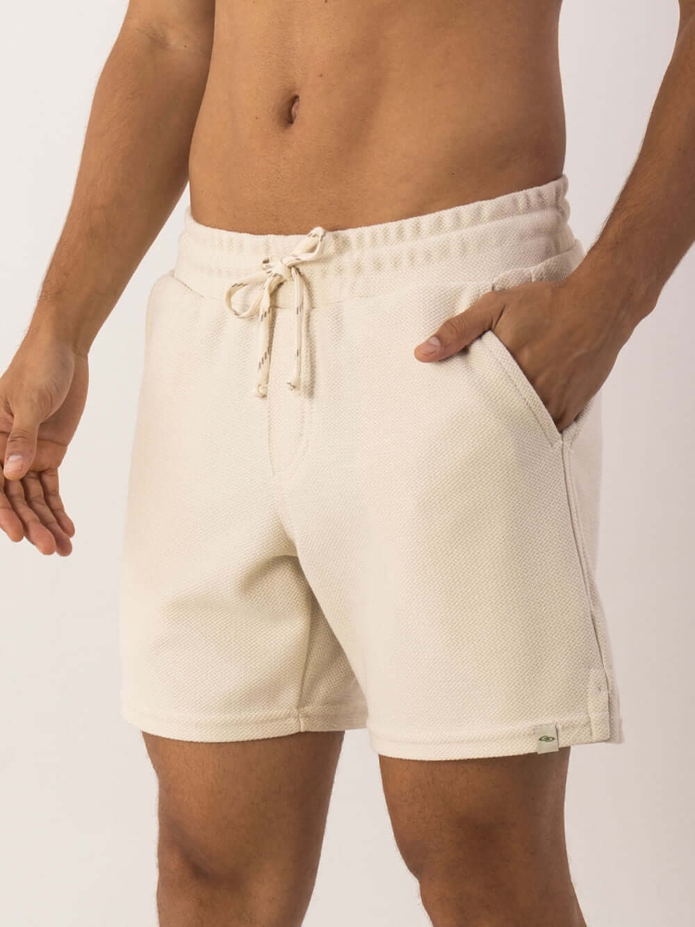 Bermuda Moletom Alpes Off White Greenish, modelagem vintage, com bolso e cós elástico para conforto e estilo.