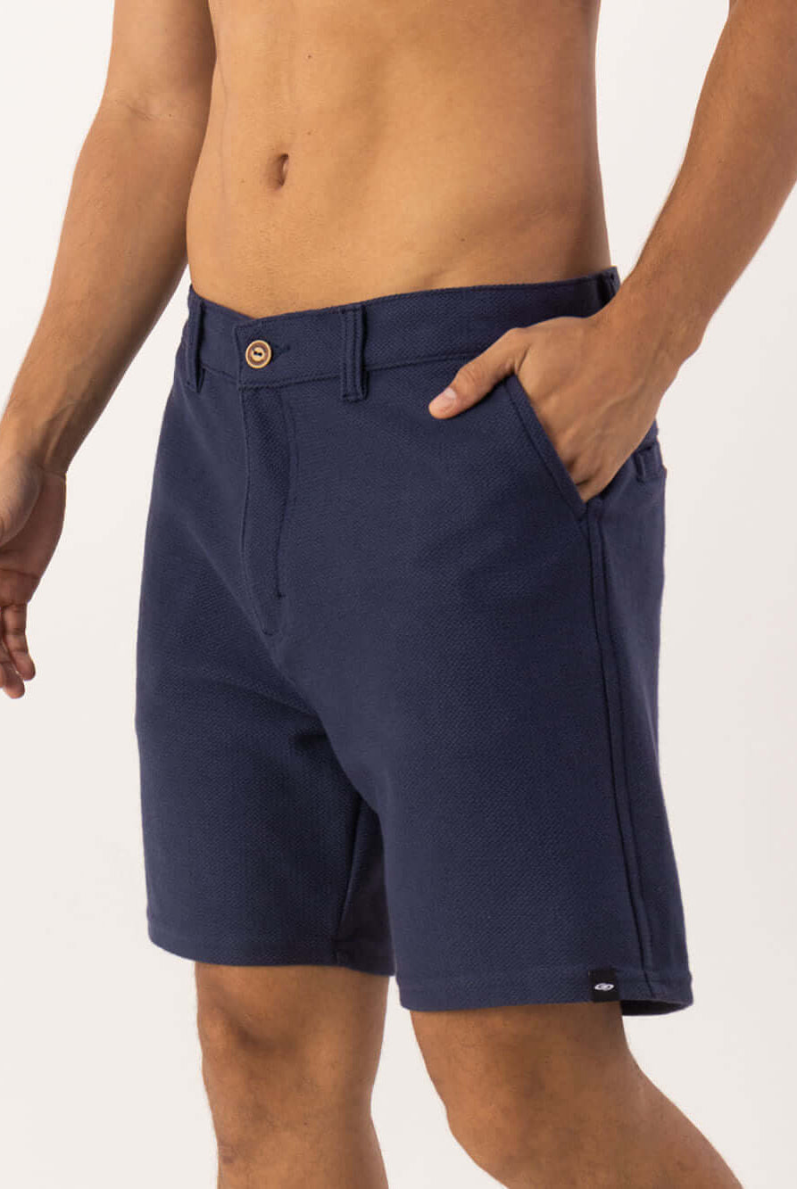 Bermuda Aspen da Greenish em azul marinho, estilo clássico e moderno, com bolsa e botão de madeira.