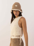 Blusa Tropical da Greenish, trançada em crochê, com decote canoa e lateral regulável para looks praianos.