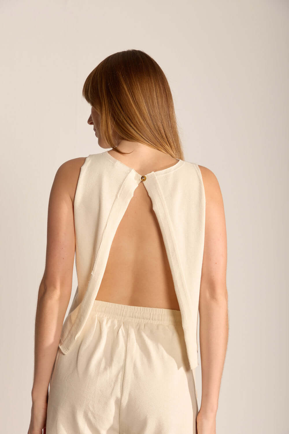 Blusa Gina bege da marca Greenish com detalhe elegante nas costas, ideal para um visual casual e sofisticado.