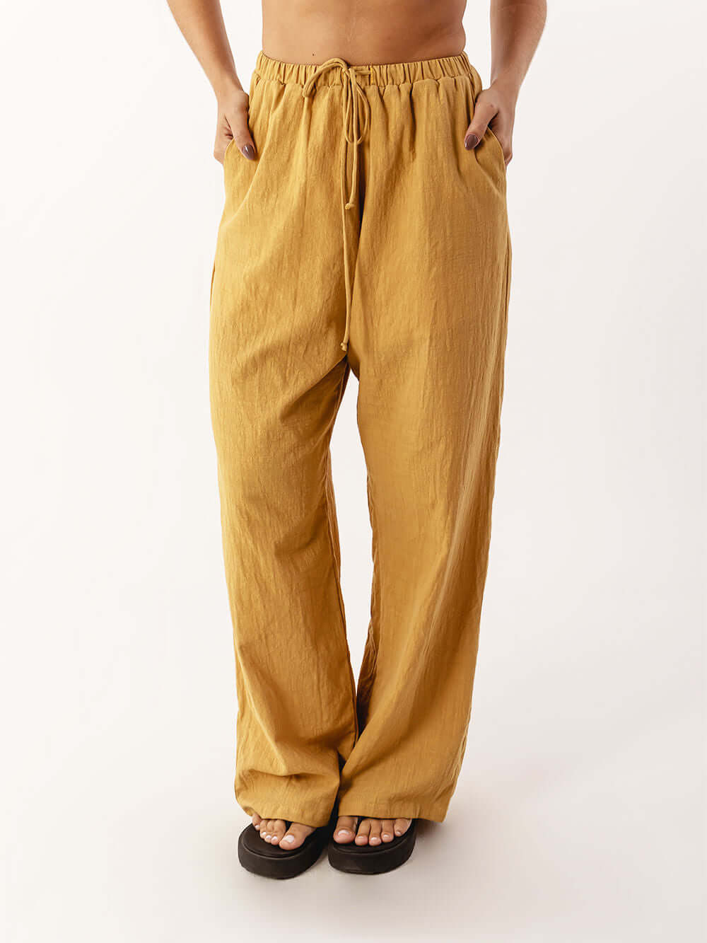 Calça Nat da Greenish em caqui, confortável e moderna, com cós elástico e bolsos, ideal para o dia a dia.