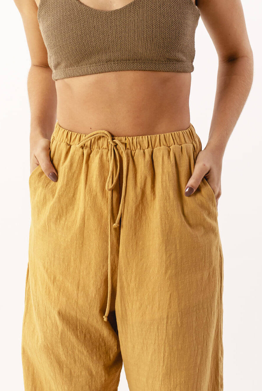 Calça Nat caqui da Greenish com cós elástico e bolso faca, ideal para conforto e estilo moderno.