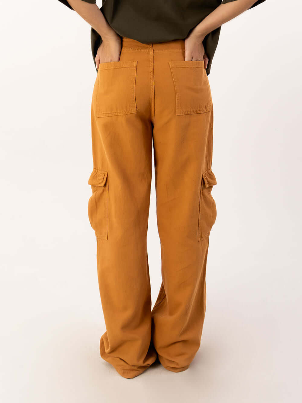 Calça cargo Lilly da Greenish na cor ocre, mostrando bolso traseiro e laterais em look moderno e prático.