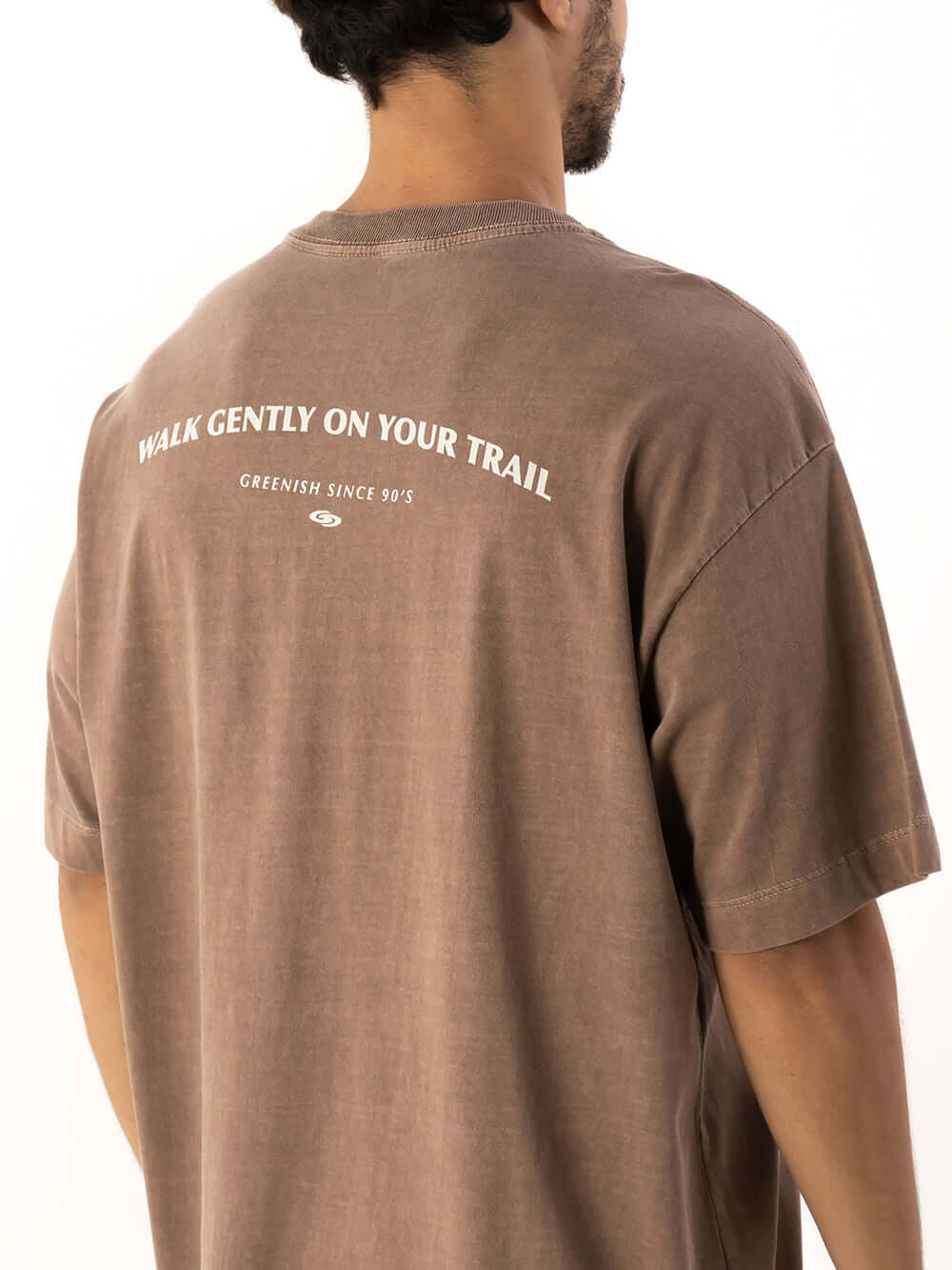 Camiseta oversized marron da Greenish com estampa "Walk Gently On Your Trail" nas costas. Estilo moderno e confortável.