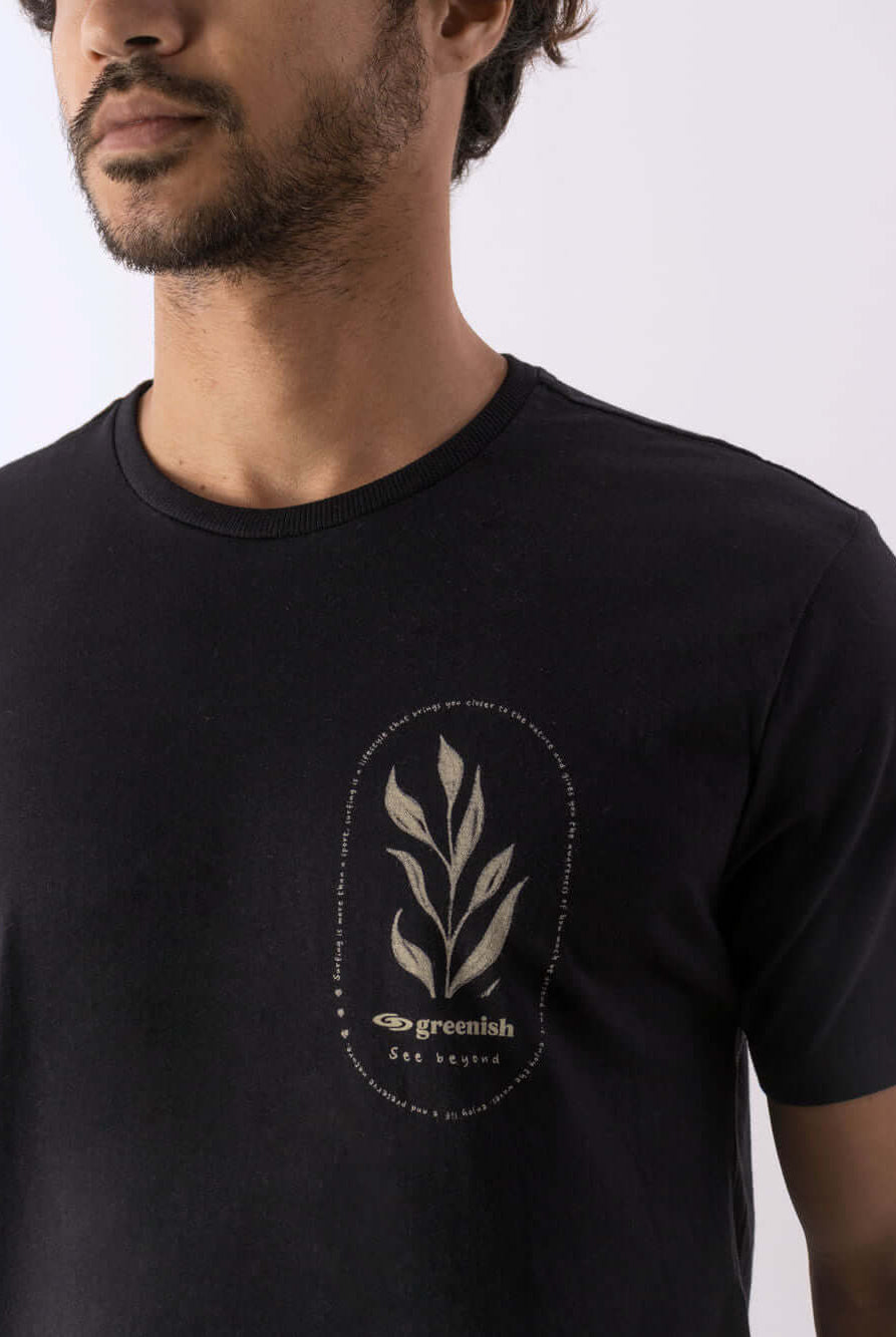 Modelo usando camiseta Natureza preta da marca Greenish com estampa original de folhas.
