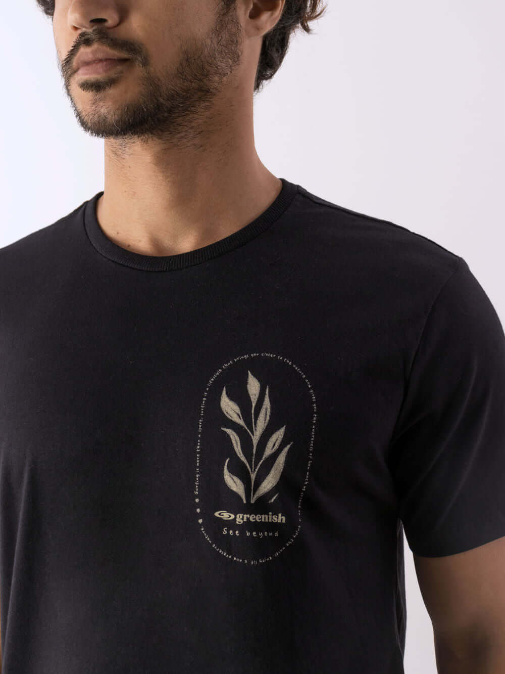 Modelo usando camiseta Natureza preta da marca Greenish com estampa original de folhas.
