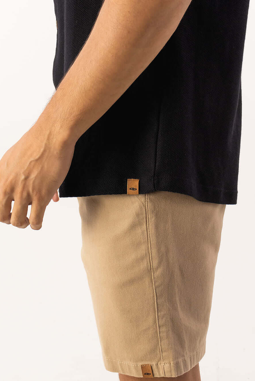Camisa preta de modelagem clássica da Greenish, em sobreposição com shorts claros, ideal para ocasiões formais.