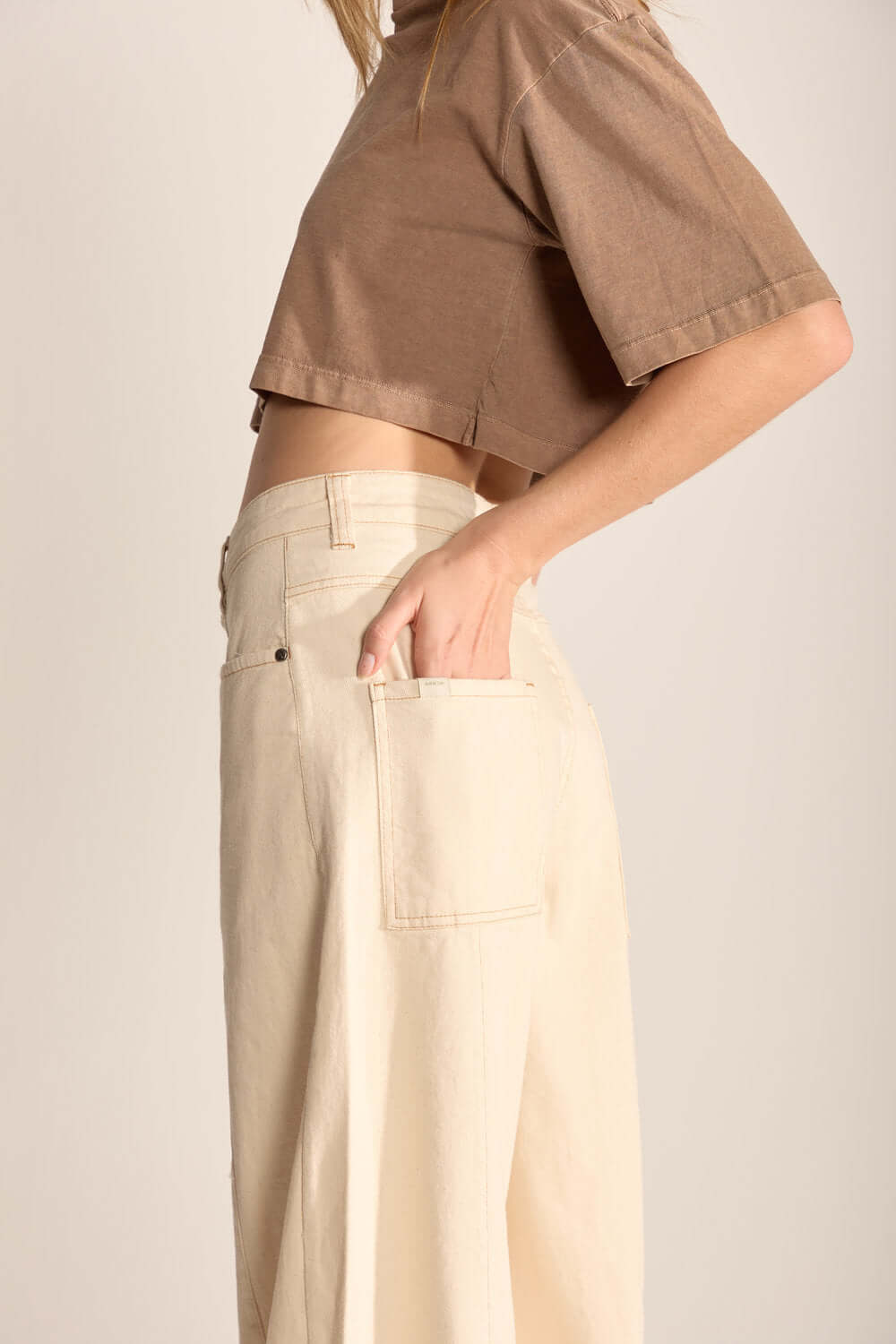 Calça Laila da Greenish em tom natural, com recortes, modelagem ampla e cintura alta, unindo conforto e estilo.
