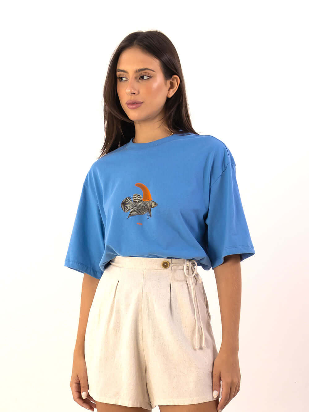 Model usando T-shirt Oversized Warning Azul da Greenish, com estampa exclusiva de peixe e short claro.
