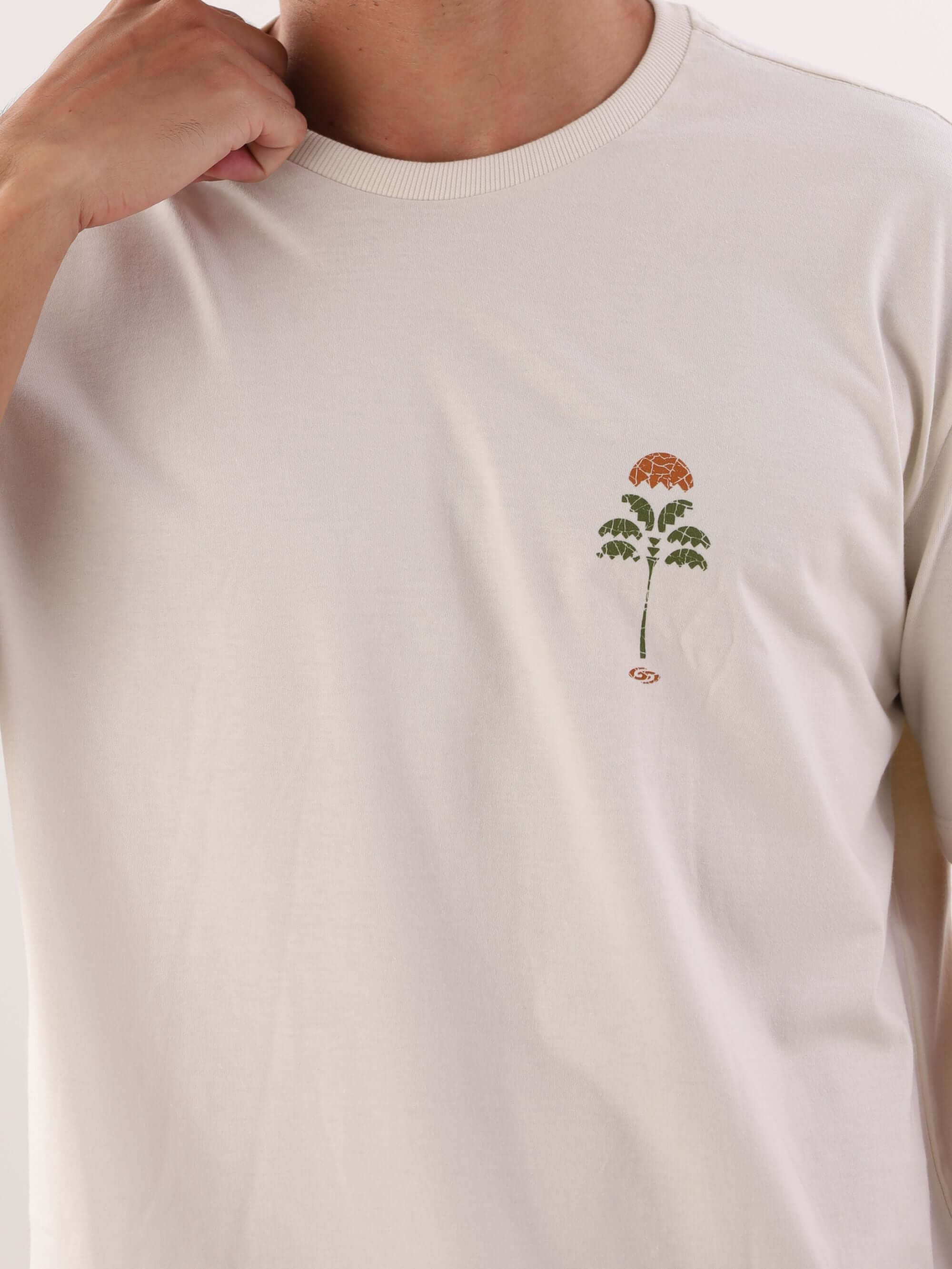 Camiseta beige "Enjoy Nature" da Greenish, com estampa de planta em destaque.