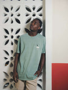 Modelo usando camiseta verde da Greenish, 100% algodão, minimalista e versátil para o dia a dia.