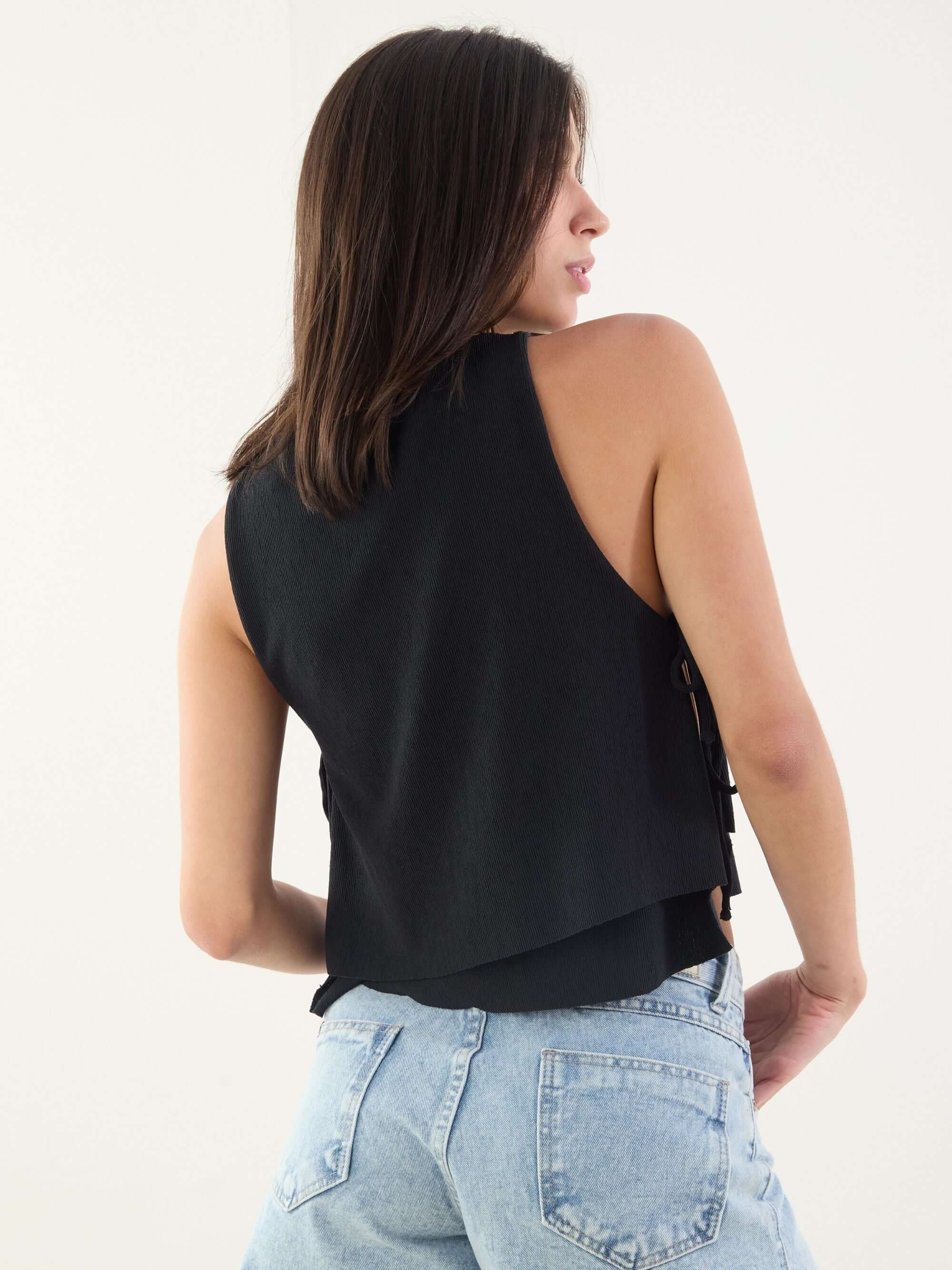 Modelo usando a Blusa Carla preta da Greenish, com amarração lateral e caimento soltinho, perfeita para qualquer estilo.